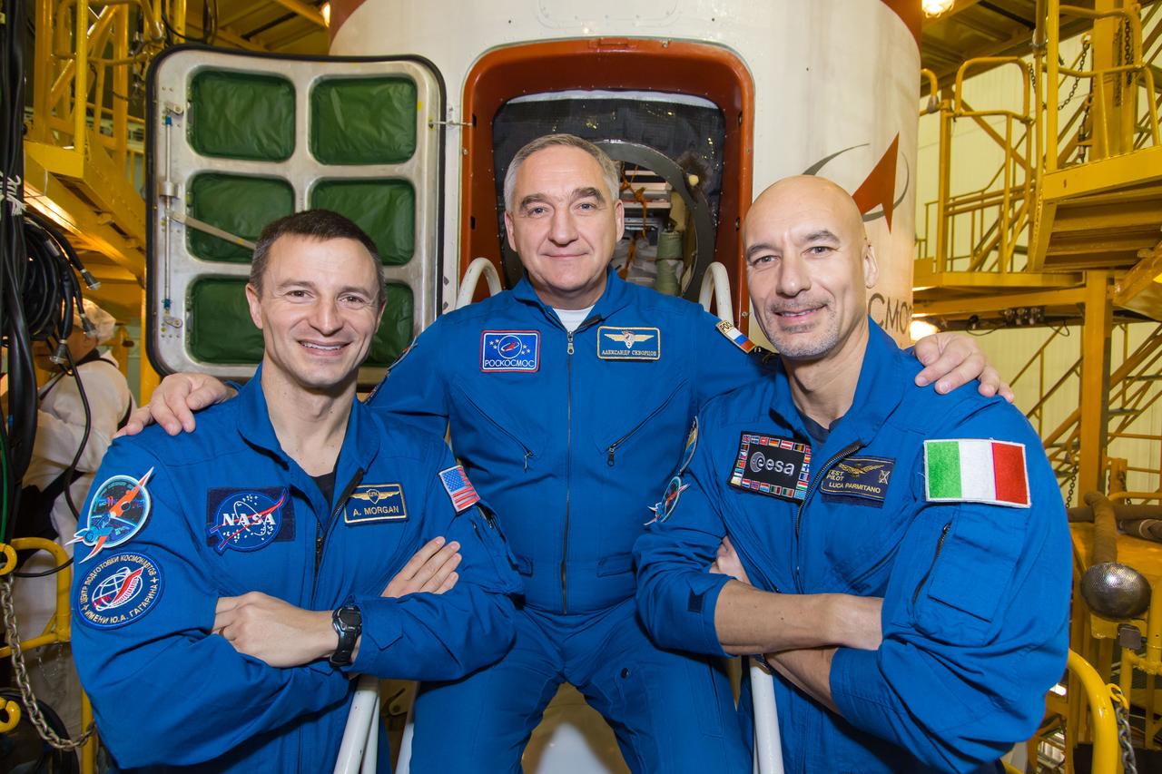 jsc2018e098088 - In the Integration Facility at the Baikonur Cosmodrome in Kazakhstan, Expedition 58 backup crewmembers Drew Morgan of NASA (left), Alexander Skvortsov of Roscosmos (center) and Luca Parmitano of the European Space Agency (right) pose for pictures Nov. 29 in front of the Soyuz MS-11 spacecraft during a final vehicle fit check. They are the backups to Anne McClain of NASA, Oleg Kononenko of Roscosmos and David Saint-Jacques of the Canadian Space Agency, who will launch Dec. 3 in the Soyuz MS-11 spacecraft from the Baikonur Cosmodrome in Kazakhstan for a six-and-a-half month mission on the International Space Station...NASA/Victor Zelentsov.