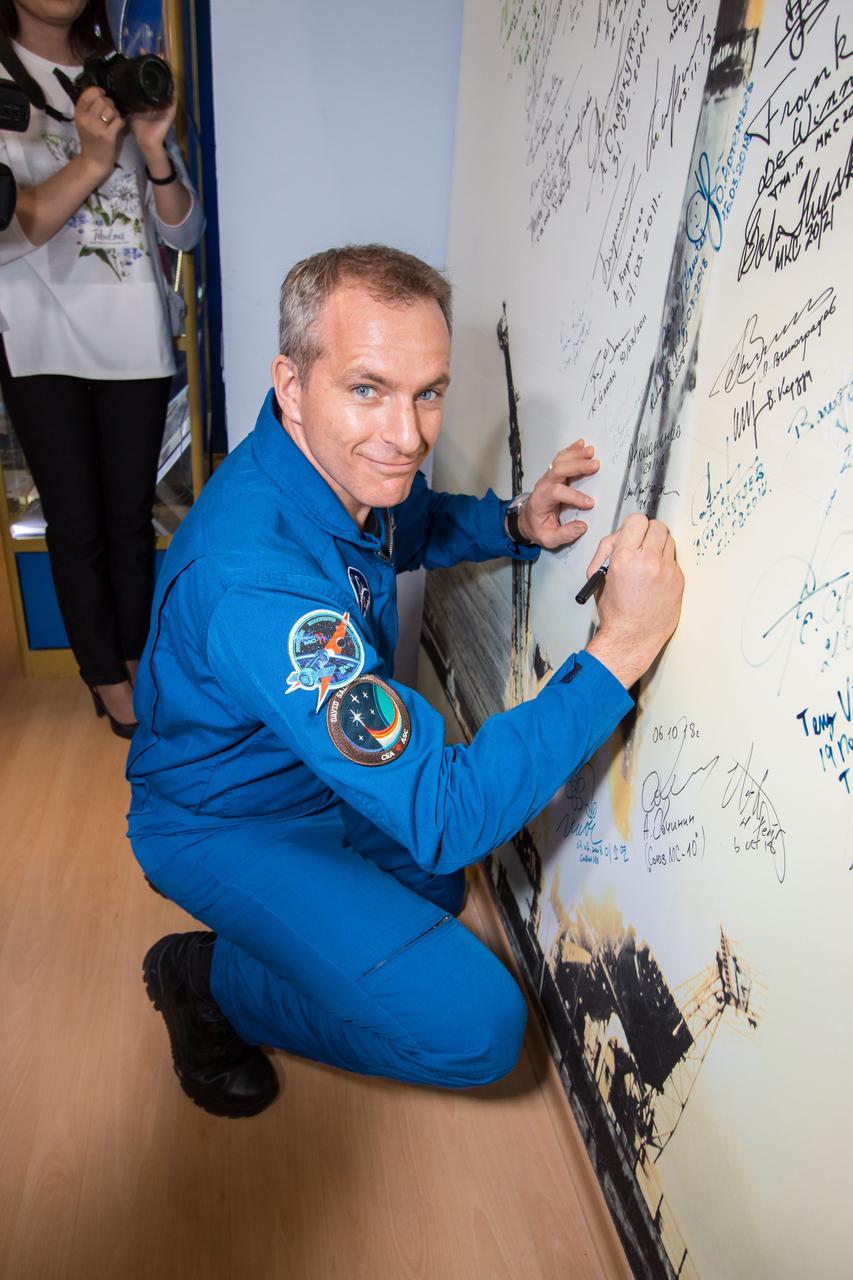 jsc2018e098092 - At the Baikonur Cosmodrome Museum in Kazakhstan, Expedition 58 crewmember David Saint-Jacques of the Canadian Space Agency signs a wall mural Nov. 29 as part of traditional pre-launch activities. Saint-Jacques, Anne McClain of NASA and Oleg Kononenko of Roscosmos will launch Dec. 3 in the Soyuz MS-11 spacecraft from the Baikonur Cosmodrome in Kazakhstan for a six-and-a-half month mission on the International Space Station...NASA/Victor Zelentsov.