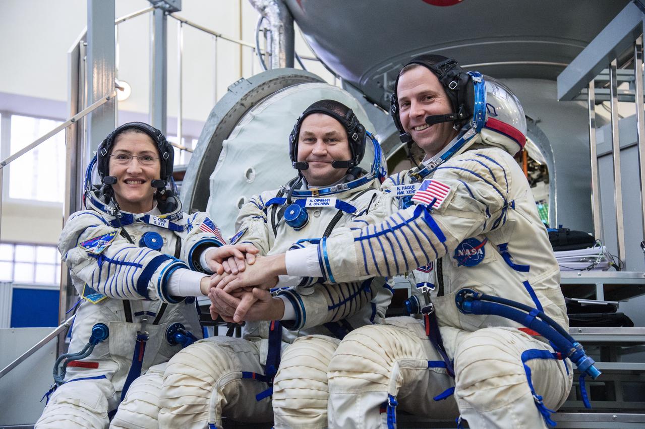 jsc2019e004056 (Feb. 20, 2019) --- At the Gagarin Cosmonaut Training Center in Star City, Russia, Expedition 59 crew members Christina Koch of NASA (left), Alexey Ovchinin of Roscosmos (center) and Nick Hague of NASA (right) pose for pictures in front of their Soyuz spacecraft simulator Feb. 20 during the second day of final pre-launch qualifications exams. They will launch March 14, U.S. time, in the Soyuz MS-12 spacecraft from the Baikonur Cosmodrome in Kazakhstan for a six-and-a-half month mission on the International Space Station. Credit: NASA/Beth Weissinger