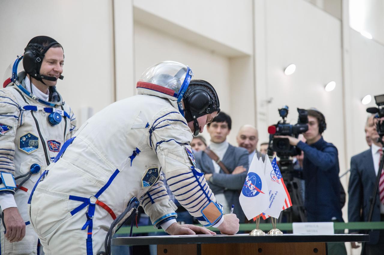 jsc2019e004063 (Feb. 20, 2019) --- At the Gagarin Cosmonaut Training Center in Star City, Russia, Expedition 59 crew member Alexey Ovchinin of Roscosmos signs in for the second day of final pre-launch qualification exams Feb. 20 as his crewmate, Nick Hague of NASA looks on. Ovchinin, Hague and Christina Koch of NASA will launch March 14, U.S. time, in the Soyuz MS-12 spacecraft from the Baikonur Cosmodrome in Kazakhstan for a six-and-a-half month mission on the International Space Station. Credit: NASA/Beth Weissinger