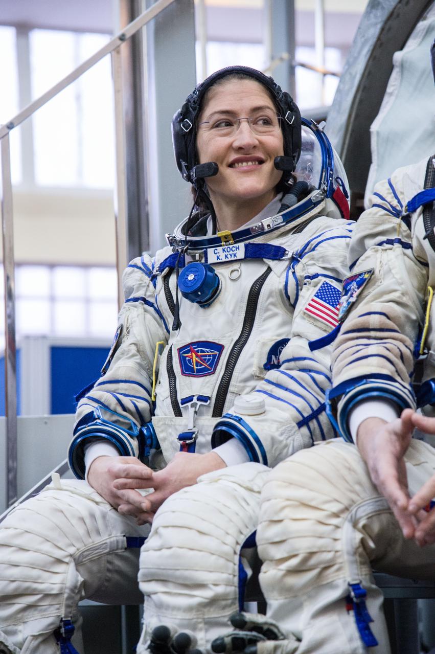 jsc2019e004068 (Feb. 20, 2019) --- At the Gagarin Cosmonaut Training Center in Star City, Russia, Expedition 59 crew member Christina Koch of NASA listens to reporters’ questions in front of a Soyuz spacecraft simulator Feb. 20 during the second day of final pre-launch qualifications exams. Koch, Nick Hague of NASA and Alexey Ovchinin of Roscosmos will launch March 14, U.S. time, in the Soyuz MS-12 spacecraft from the Baikonur Cosmodrome in Kazakhstan for a six-and-a-half month mission on the International Space Station. Credit: NASA/Beth Weissinger