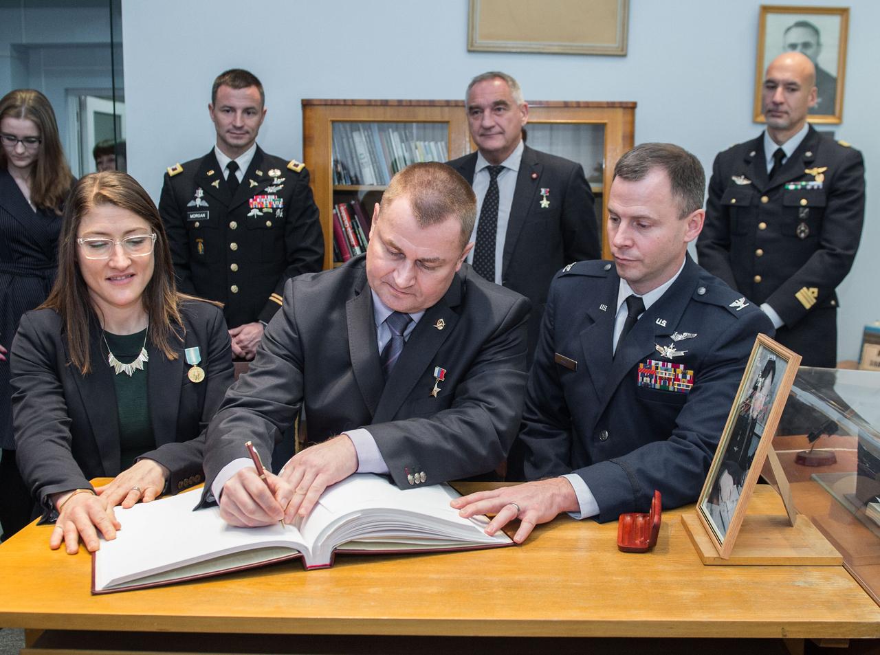 At the Gagarin Museum in the Gagarin Cosmonaut Training Center in Star City, Russia, Expedition 59 crewmembers Christina Koch of NASA (front, left), Alexey Ovchinin of Roscosmos (front, center) and Nick Hague of NASA (front, right) sign a ceremonial book Feb. 21 as part of their pre-launch activities as their backups in the back row, Drew Morgan of NASA, Alexander Skvortsov of Roscosmos and Luca Parmitano of the European Space Agency look on. Koch, Hague and Ovchinin will launch March 14, U.S. time, on the Soyuz MS-12 spacecraft from the Baikonur Cosmodrome in Kazakhstan for a six-and-a-half month mission on the International Space Station.  Irina Spektor/Gagarin Cosmonaut Training Center 