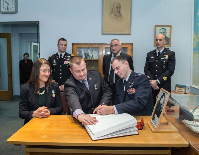 NASA image: jsc2019e004425 - At the Gagarin Museum in the Gagarin Cosmonaut Training Center in Star City, Russia, Expedition 59 crewmember Nick Hague of NASA (front, right) signs a ceremonial book Feb. 21 as part of the crewâ€™s pre-launch activities as his crewmates