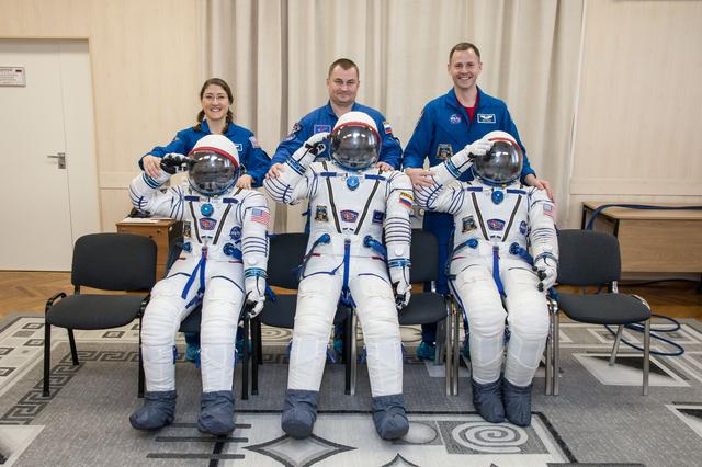 NASA image: jsc2019e009960 - At the Baikonur Cosmodrome in Kazakhstan Expedition 59 crewmembers Christina Koch of NASA (left), Alexey Ovchinin of Roscosmos (center) and Nick Hague of NASA (right) share a playful moment with their Sokol launch and entry suits Feb. 27 