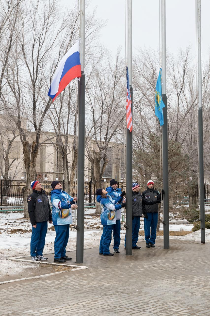jsc2019e011272 - At their Cosmonaut Hotel crew quarters in Baikonur, Kazakhstan, the Expedition 59 prime and backup crewmembers conduct the traditional raising of the flags of Russia, the U.S. and Kazakhstan Feb. 28 as part of their pre-launch training. From left to right raising the Russian flag are Alexander Skvortsov and Alexey Ovchinin of Roscosmos, raising the U.S. flag are Nick Hague and Christina Koch of NASA and raising the Kazakh flag are Drew Morgan of NASA and Luca Parmitano of the European Space Agency. Hague, Ovchinin and Koch will launch March 14, U.S. time, in the Soyuz MS-12 spacecraft from the Baikonur Cosmodrome in Kazakhstan for a six-and-a-half month mission on the International Space Station...NASA/Victor Zelentsov.