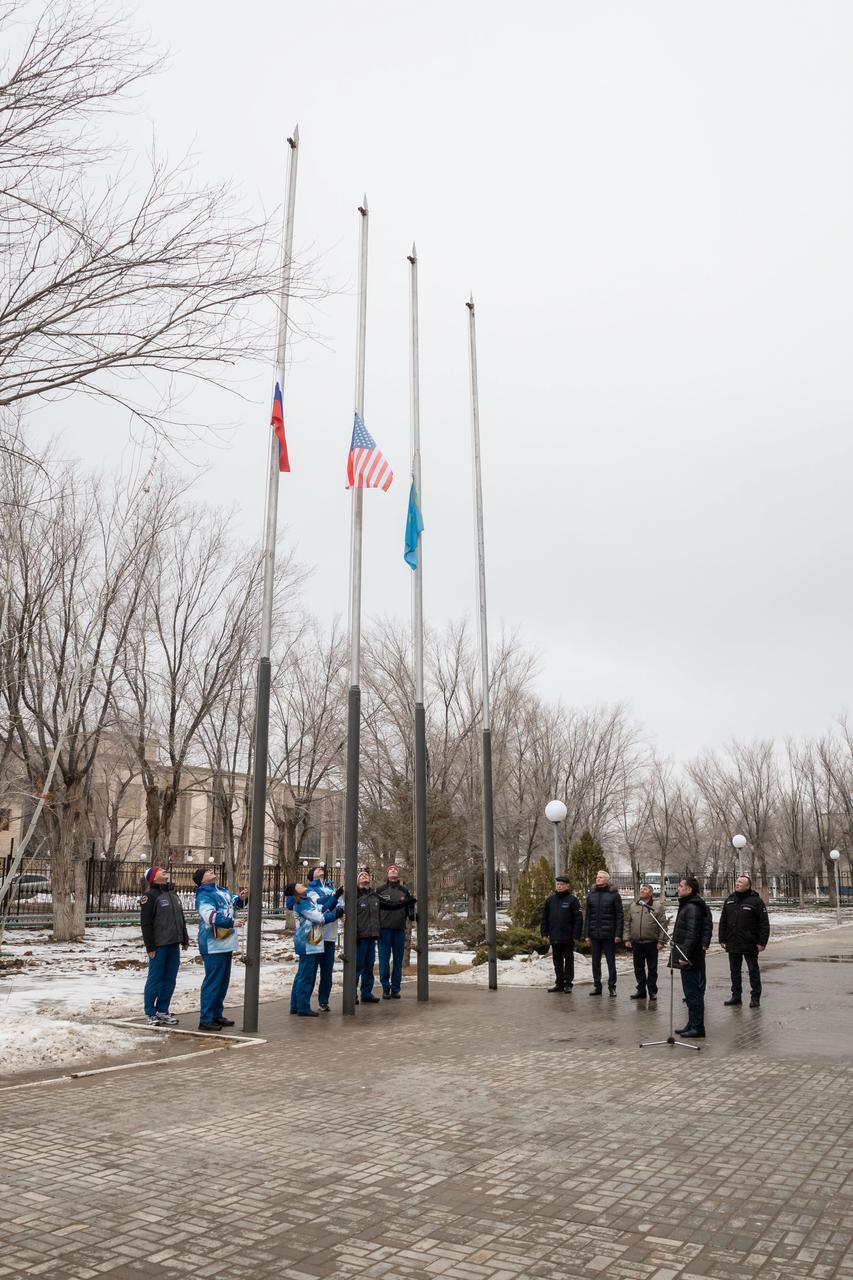 jsc2019e011273 - At their Cosmonaut Hotel crew quarters in Baikonur, Kazakhstan, the Expedition 59 prime and backup crewmembers conduct the traditional raising of the flags of Russia, the U.S. and Kazakhstan Feb. 28 as part of their pre-launch training. From left to right raising the Russian flag are Alexander Skvortsov and Alexey Ovchinin of Roscosmos, raising the U.S. flag are Nick Hague and Christina Koch of NASA and raising the Kazakh flag are Drew Morgan of NASA and Luca Parmitano of the European Space Agency. Hague, Ovchinin and Koch will launch March 14, U.S. time, in the Soyuz MS-12 spacecraft from the Baikonur Cosmodrome in Kazakhstan for a six-and-a-half month mission on the International Space Station...NASA/Victor Zelentsov.