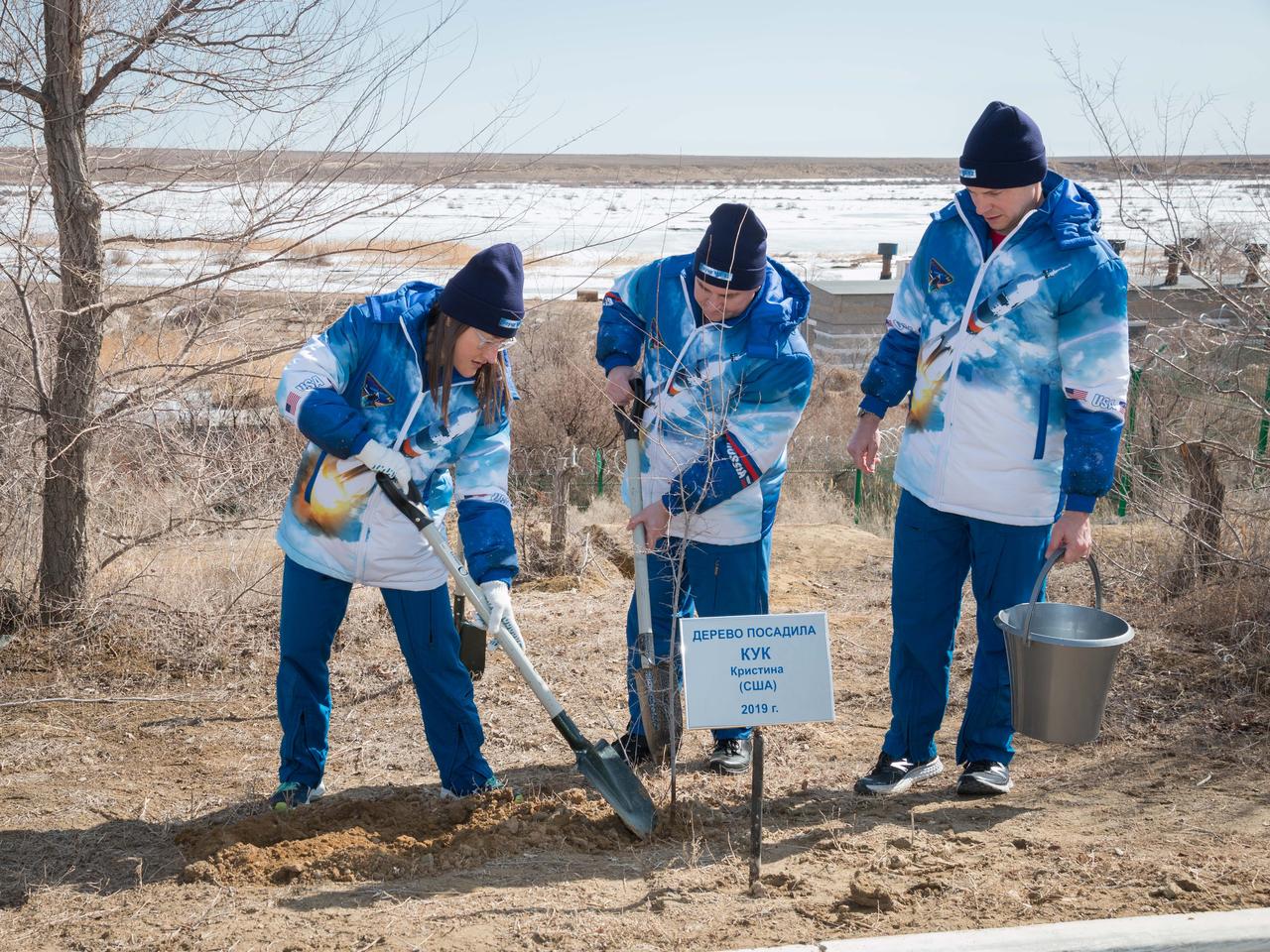 At the Cosmonaut Hotel crew quarters in Baikonur, Kazakhstan, Expedition 59 crewmember Christina Koch of NASA (left) plants a tree in her name March 7 in traditional pre-launch activities. Assisting her are crewmates Alexey Ovchinin of Roscosmos (center) and Nick Hague of NASA (right). They will launch March 14, U.S. time, on the Soyuz MS-12 spacecraft from the Baikonur Cosmodrome for a six-and-a-half month mission on the International Space Station...NASA/Victor Zelentsov.