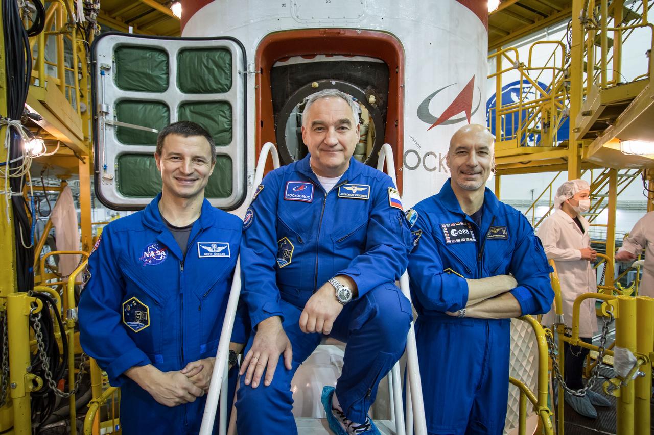 jsc2019e013410 - In the Integration Building at the Baikonur Cosmodrome in Kazakhstan, Expedition 59 backup crewmembers Drew Morgan of NASA (left), Alexander Skvortsov of Roscosmos (center) and Luca Parmitano of the European Space Agency (right) pose for pictures in front of the Soyuz MS-12 spacecraft March 10 during final pre-launch inspections. They are the backups to the prime crewmembers, Nick Hague and Christina Koch of NASA and Alexey Ovchinin of Roscosmos, who will launch March 14, U.S. time, in the Soyuz MS-12 spacecraft from the Baikonur Cosmodrome for a six-and-a-half month mission on the International Space Station...NASA/Victor Zelentsov.