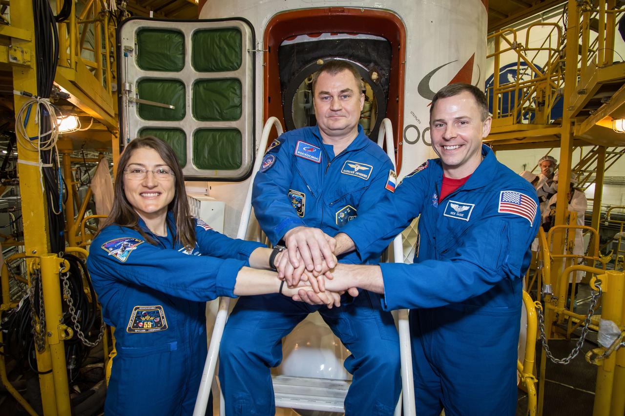 jsc2019e013412 - In the Integration Building at the Baikonur Cosmodrome in Kazakhstan, Expedition 59 crewmembers Christina Koch of NASA (left), Alexey Ovchinin of Roscosmos (center) and Nick Hague of NASA (right) pose for pictures in front of the Soyuz MS-12 spacecraft March 10 during final pre-launch inspections. They will launch March 14, U.S. time, in the Soyuz MS-12 spacecraft from the Baikonur Cosmodrome for a six-and-a-half month mission on the International Space Station...NASA/Victor Zelentsov.