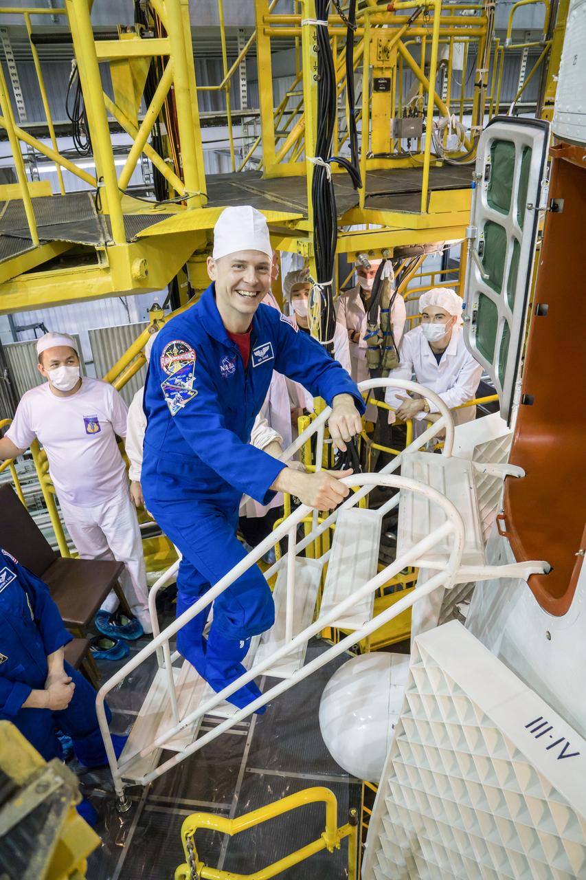 jsc2019e013413 - In the Integration Building at the Baikonur Cosmodrome in Kazakhstan, Expedition 59 crewmember Nick Hague of NASA poses for pictures March 10 as he climbs aboard the Soyuz MS-12 spacecraft for final pre-launch preparations. Hague, Christina Koch of NASA and Alexey Ovchinin of Roscosmos will launch March 14, U.S. time, in the Soyuz MS-12 spacecraft from the Baikonur Cosmodrome for a six-and-a-half month mission on the International Space Station...NASA/Victor Zelentsov.