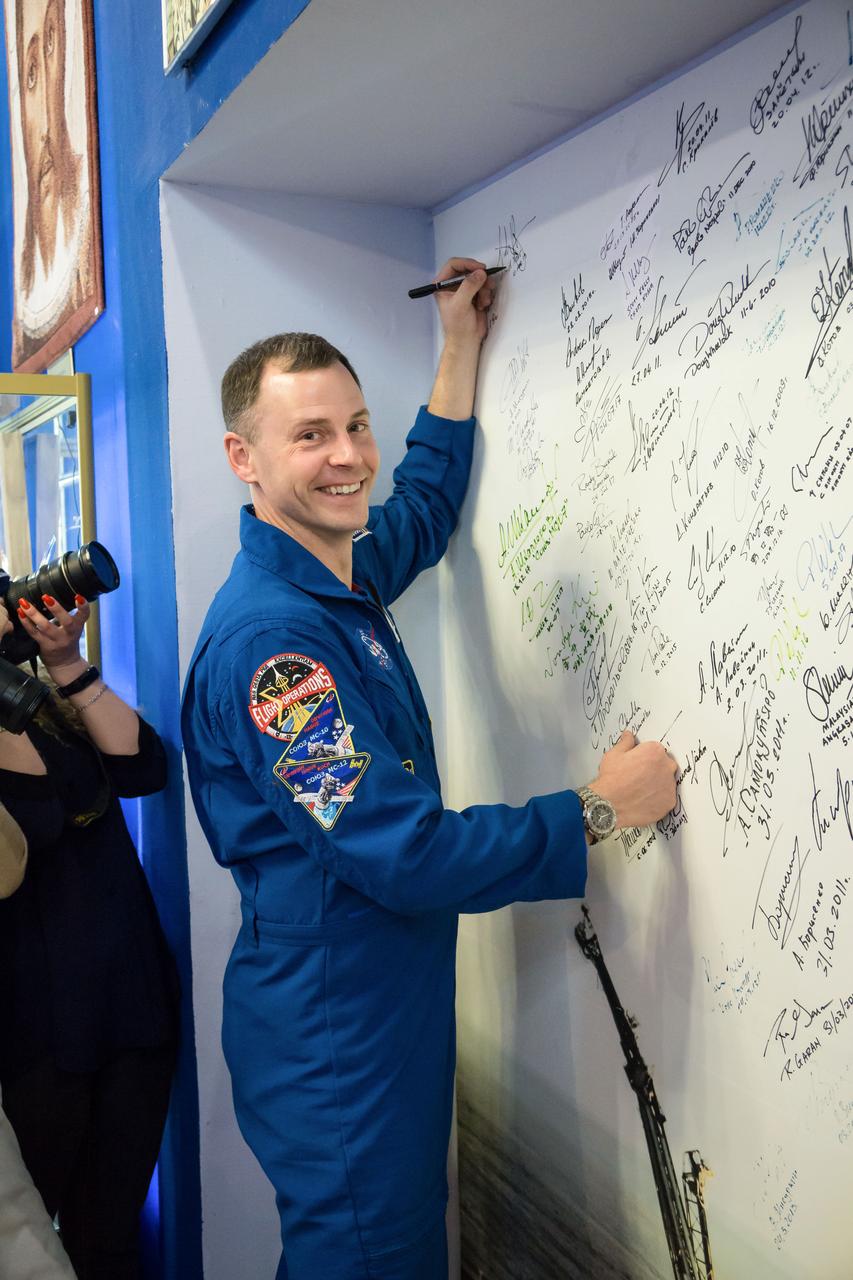 jsc2019e013415 - At the Baikonur Cosmodrome Museum in Kazakhstan, Expedition 59 crewmember Nick Hague of NASA signs a wall mural bearing the names of those who have flown in space March 10 in traditional pre-launch activities. Hague, Christina Koch of NASA and Alexey Ovchinin of Roscosmos will launch March 14, U.S. time, in the Soyuz MS-12 spacecraft from the Baikonur Cosmodrome for a six-and-a-half month mission on the International Space Station...NASA/Victor Zelentsov..
