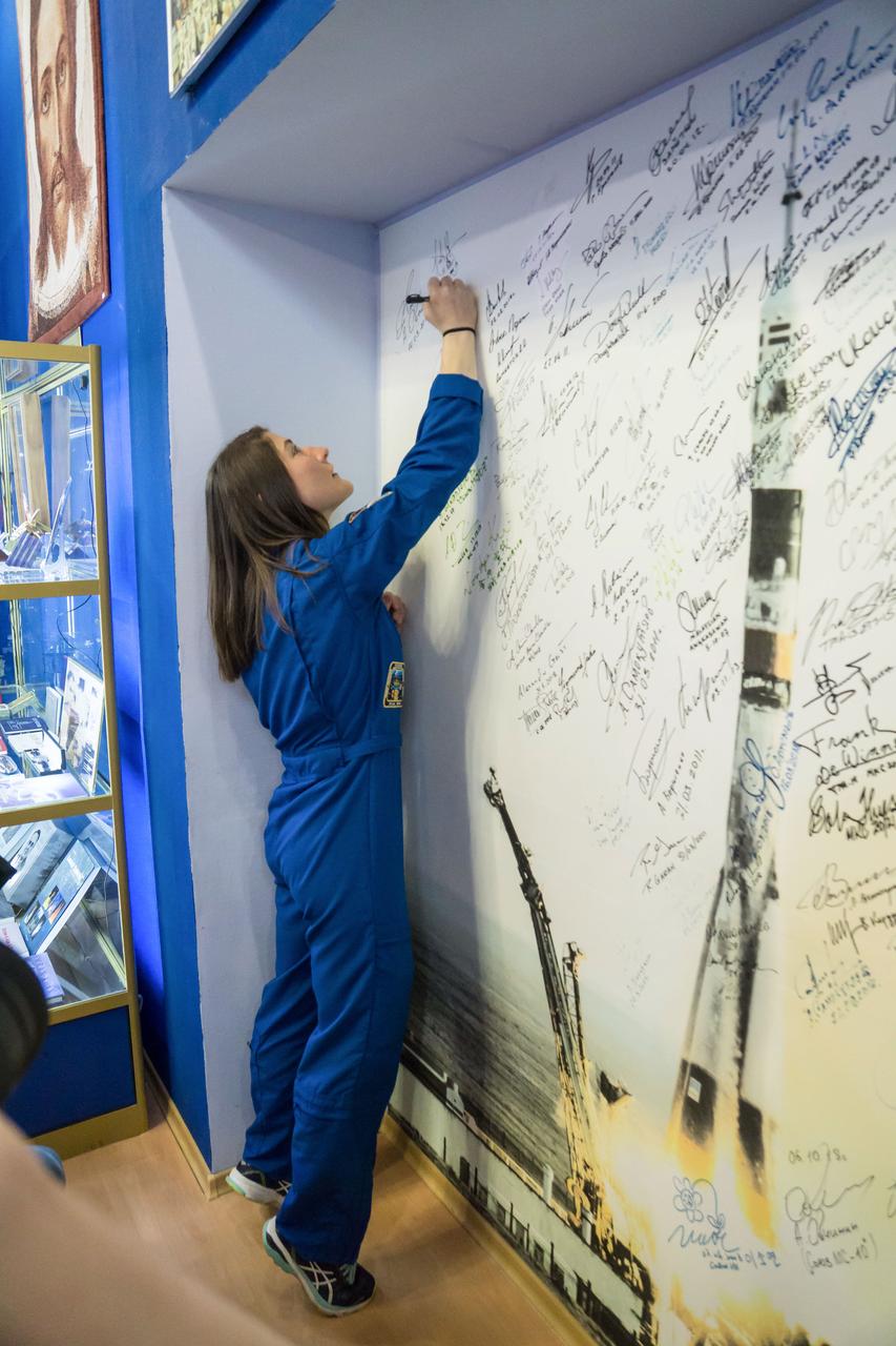 jsc2019e013416 - At the Baikonur Cosmodrome Museum in Kazakhstan, Expedition 59 crewmember Christina Koch of NASA signs a wall mural bearing the names of those who have flown in space March 10 in traditional pre-launch activities. Koch, Nick Hague of NASA and Alexey Ovchinin of Roscosmos will launch March 14, U.S. time, in the Soyuz MS-12 spacecraft from the Baikonur Cosmodrome for a six-and-a-half month mission on the International Space Station...NASA/Victor Zelentsov.