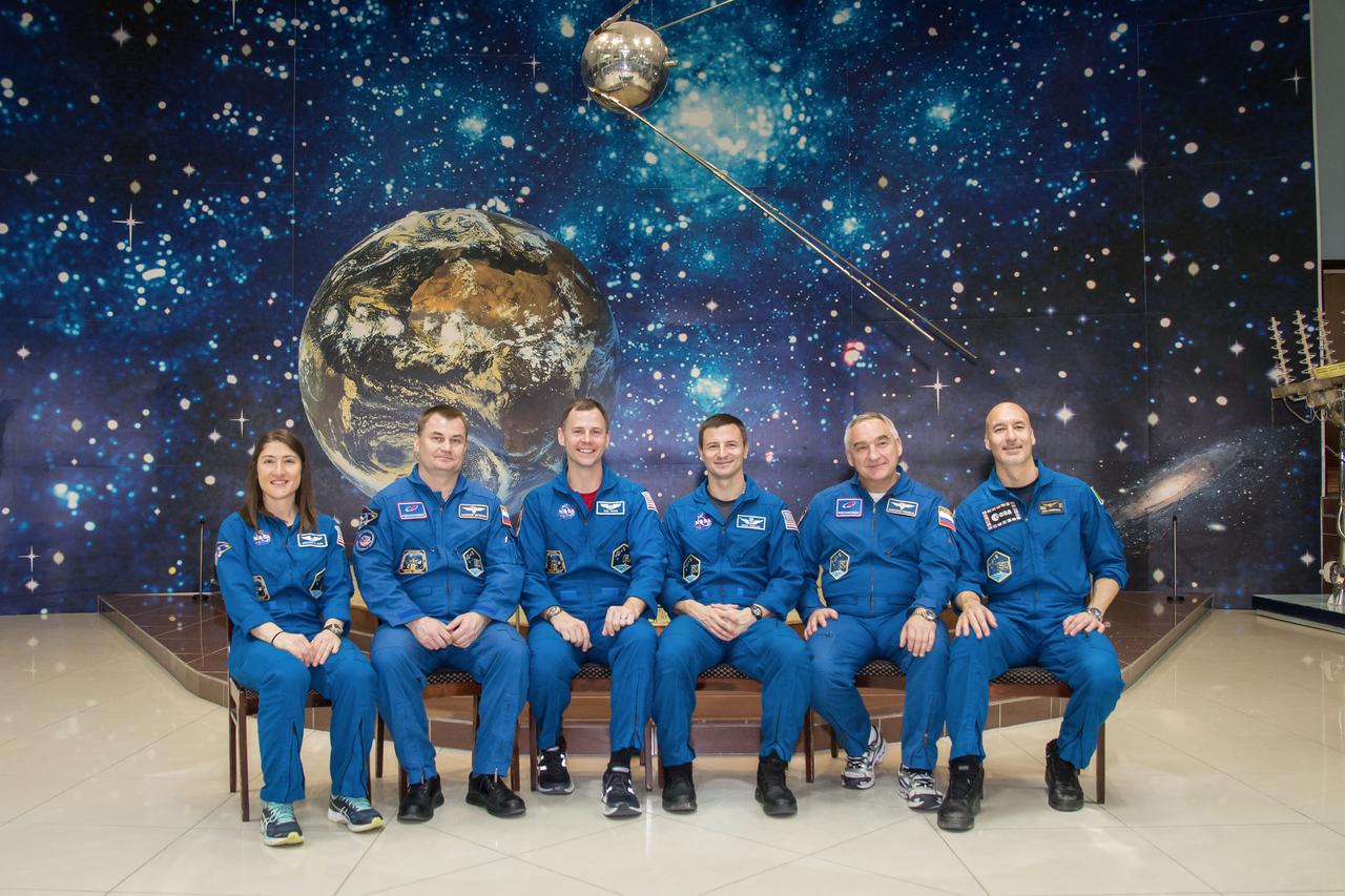 jsc2019e013418 - At the Baikonur Cosmodrome Museum in Kazakhstan, a model of the world’s first satellite, Sputnik, serves as a hanging backdrop March 10 as the Expedition 59 prime and backup crewmembers pose for pictures in traditional pre-launch activities. From left to right are the prime crewmembers, Christina Koch of NASA, Alexey Ovchinin of Roscosmos and Nick Hague of NASA, and the backup crewmembers, Drew Morgan of NASA, Alexander Skvortsov of Roscosmos and Luca Parmitano of the European Space Agency. Koch, Hague and Ovchinin will launch March 14, U.S. time, in the Soyuz MS-12 spacecraft from the Baikonur Cosmodrome for a six-and-a-half month mission on the International Space Station...NASA/Victor Zelentsov.