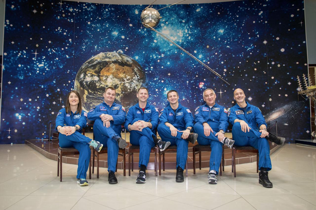 jsc2019e013419 - At the Baikonur Cosmodrome Museum in Kazakhstan, a model of the world’s first satellite, Sputnik, serves as a hanging backdrop March 10 as the Expedition 59 prime and backup crewmembers pose for pictures in traditional pre-launch activities. From left to right are the prime crewmembers, Christina Koch of NASA, Alexey Ovchinin of Roscosmos and Nick Hague of NASA, and the backup crewmembers, Drew Morgan of NASA, Alexander Skvortsov of Roscosmos and Luca Parmitano of the European Space Agency. Koch, Hague and Ovchinin will launch March 14, U.S. time, in the Soyuz MS-12 spacecraft from the Baikonur Cosmodrome for a six-and-a-half month mission on the International Space Station...NASA/Victor Zelentsov.