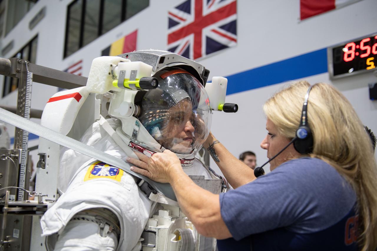 jsc2019e030037 (05-22-19) --- 2017 NASA astronaut candidate Jessica Watkins is helped into a spacesuit prior to underwater spacewalk training at NASA Johnson Space Center’s Neutral Buoyancy Laboratory in Houston. Photo Credit: (NASA/David DeHoyos)