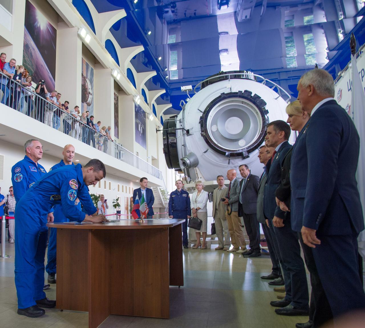 jsc2019e035255 - At the Gagarin Cosmonaut Training Center in Star City, Russia, Expedition 60 crewmember Drew Morgan of NASA signs in June 26 for the first day of final qualification exams. Looking on are crewmates Alexander Skvortsov of Roscosmos and Luca Parmitano of the European Space Agency. They will launch July 20 on the Soyuz MS-13 spacecraft from the Baikonur Cosmodrome in Kazakhstan for a mission on the International Space Station...NASA/Beth Weissinger.