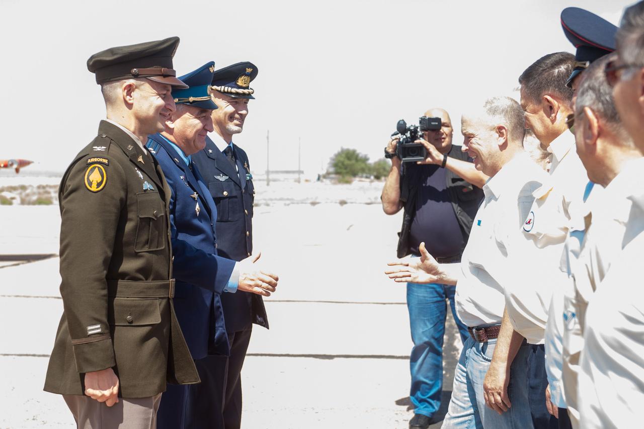 jsc2019e038370 - At the Baikonur Cosmodrome in Kazakhstan, Expedition 60 crewmembers Drew Morgan of NASA (left), Alexander Skvortsov of Roscosmos (center) and Luca Parmitano of the European Space Agency (right) are greeted by Russian space officials July 4 for final pre-launch preparations after a flight from their training base outside Moscow. They will launch July 20 from the Baikonur Cosmodrome in Kazakhstan on the Soyuz MS-13 spacecraft for a mission on the International Space Station...Andrey Shelepin/GCTC.