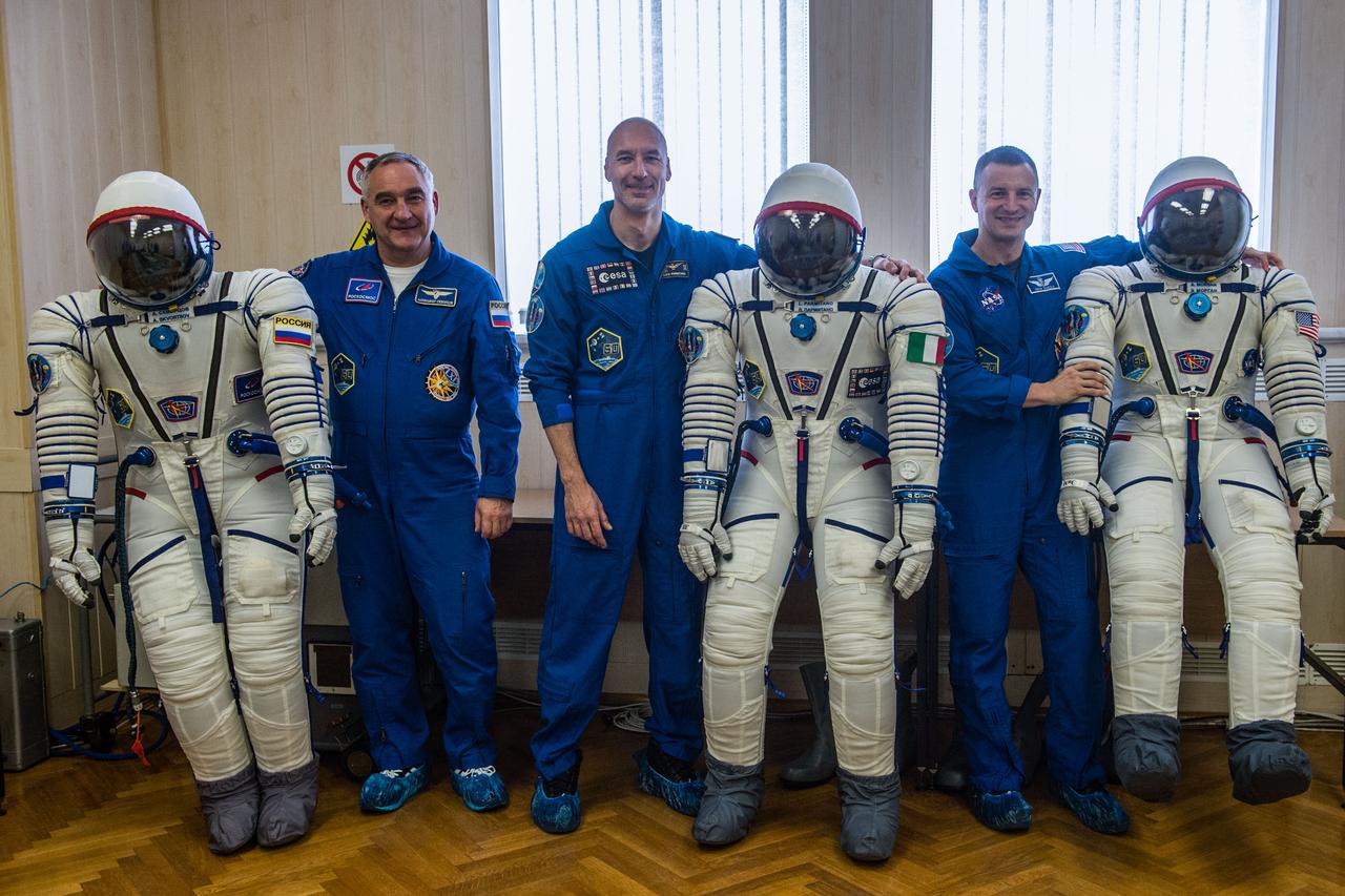 jsc2019e038383 - At the Baikonur Cosmodrome in Kazakhstan, Expedition 60 crewmembers Alexander Skvortsov of Roscosmos (left), Luca Parmitano of the European Space Agency (center) and Drew Morgan of NASA (right) pose for pictures with their Sokol launch and entry suits July 5 during pre-launch preparations. They will launch July 20 on the Soyuz MS-13 spacecraft from the Baikonur Cosmodrome for a mission on the International Space Station...Andrey Shelepin/GCTC.
