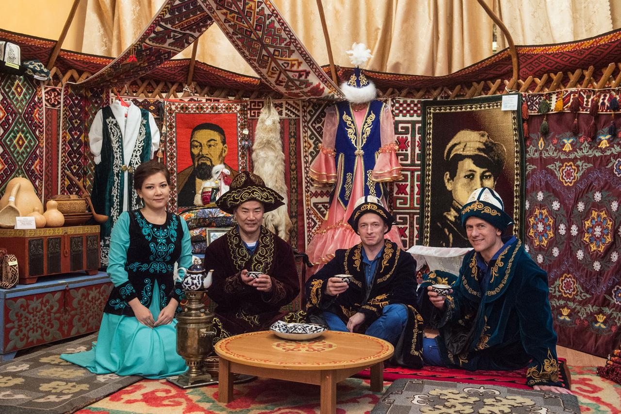jsc2019e038391 - At the Baikonur Museum in the town of Baikonur, Kazakhstan, Expedition 60 backup crewmembers Soichi Noguchi of the Japan Aerospace Exploration Agency (second from left), Sergey Ryzhikov of Roscosmos (second from right) and Tom Marshburn of NASA (right) pose for pictures July 6 in traditional Kazakh garb in a yurt, or Kazakh dwelling, during pre-launch activities. They are the backups to the prime crew, Drew Morgan of NASA, Luca Parmitano of the European Space Agency and Alexander Skvortsov of Roscosmos, who will launch July 20 on the Soyuz MS-13 spacecraft from the Baikonur Cosmodrome in Kazakhstan for a mission on the International Space Station...Andrey Shelepin/GCTC..
