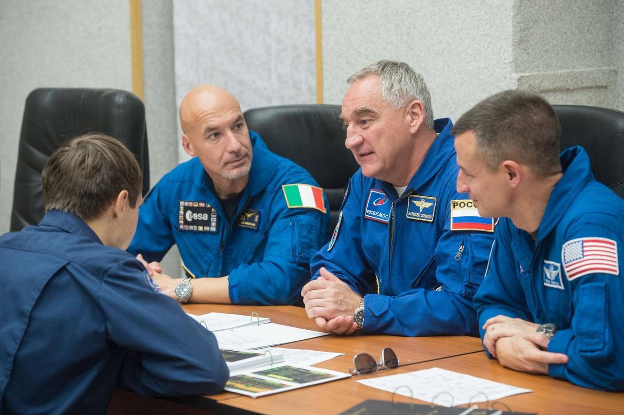jsc2019e039270 - At the Cosmonaut Hotel crew quarters in Baikonur, Kazakhstan, Expedition 60 crewmembers Luca Parmitano of the European Space Agency (left), Alexander Skvortsov of Roscosmos (center) and Drew Morgan of NASA (right) review flight plan procedures with instructors July 12 as part of pre-launch activities. They will launch July 20 on the Soyuz MS-13 spacecraft from the Baikonur Cosmodrome in Kazakhstan on a mission to the International Space Station...Andrey Shelepin/GCTC.