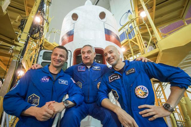jsc2019e039427 - At the Baikonur Cosmodrome in Kazakhstan, Expedition 60 crewmembers Drew Morgan of NASA (left), Alexander Skvortsov of Roscosmos (center) and Luca Parmitano of the European Space Agency (right) pose for pictures in front of the Soyuz MS-13 spacecraft July 16 as part of pre-launch preparations. They will launch July 20 on the Soyuz MS-13 spacecraft from the Baikonur Cosmodrome for a mission on the International Space Station...Andrey Shelepin/GCTC.