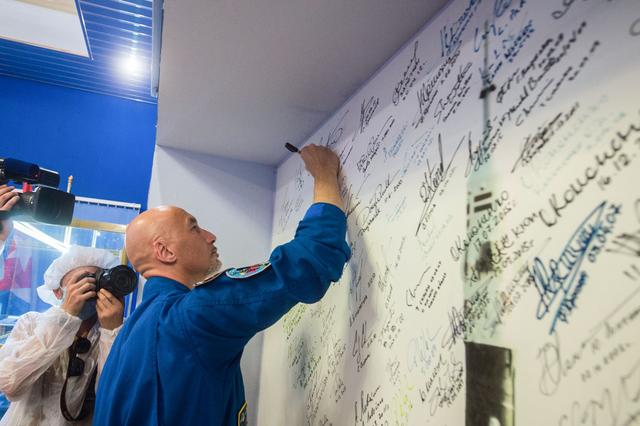 jsc2019e039433 - At the Baikonur Cosmodrome in Kazakhstan, Expedition 60 crewmember Luca Parmitano of the European Space Agency signs a wall mural July 16 as part of pre-launch preparations. Parmitano, Drew Morgan of NASA and Alexander Skvortsov of Roscosmos will launch July 20 on the Soyuz MS-13 spacecraft from the Baikonur Cosmodrome for a mission on the International Space Station...Andrey Shelepin/GCTC.