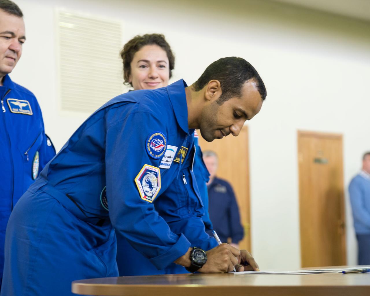 jsc2019e051811 - At the Gagarin Cosmonaut Training Center in Star City, Russia, United Arab Emirates spaceflight participant Hazzaa Ali Almansoori signs in Aug. 29 for the first day of qualification exams for flight. Looking on are Expedition 61 crewmembers Oleg Skripochka of Roscosmos and Jessica Meir of NASA. They will launch Sept. 25 from the Baikonur Cosmodrome in Kazakhstan on the Soyuz MS-15 spacecraft for a mission on the International Space Station...NASA/Beth Weissinger.