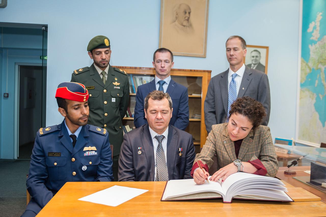 jsc2019e052239 - At the Gagarin Cosmonaut Training Center in Star City, Russia, Expedition 61 crewmember Jessica Meir of NASA signs a commemorative book in the Gagarin Museum Sept. 5 as part of pre-launch activities. Looking on in the front row are prime crewmates, spaceflight participant Hazzaa Ali Almansoori of the United Arab Emirates (left) and Expedition 61 Soyuz commander Oleg Skripochka of Roscosmos (center). In the back row are the backups, spaceflight participant Sultan Al-Neyadi of the United Arab Emirates, Sergey Ryzhikov of Roscosmos and Tom Marshburn of NASA. Meir, Skripochka and Almansoori will launch Sept. 25 from the Baikonur Cosmodrome in Kazakhstan on the Soyuz MS-15 spacecraft for a mission on the International Space Station...Irina Spector/Gagarin Cosmonaut Training Center.