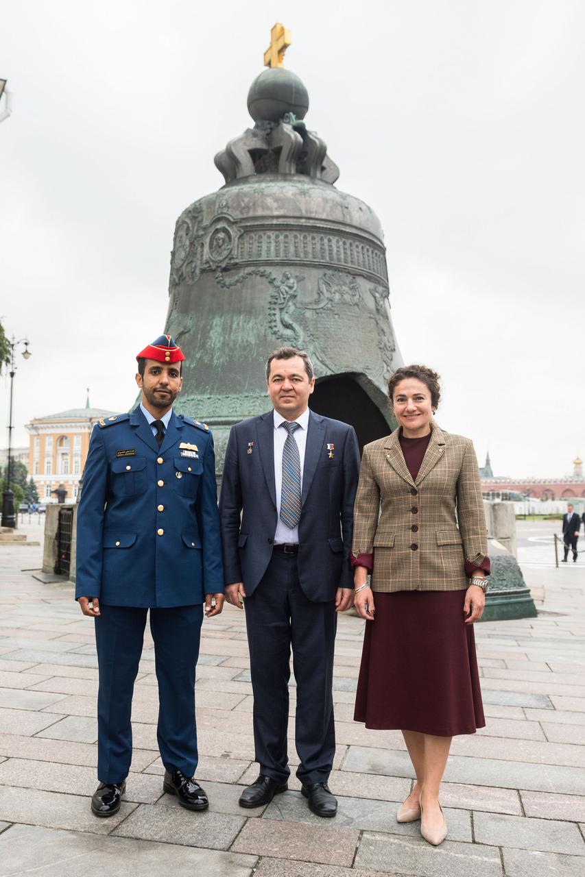 jsc2019e052241 - Inside the Kremlin in Moscow, spaceflight participant Hazzaa Ali Almansoori of the United Arab Emirates (left) and Expedition 61 crewmembers Oleg Skripochka of Roscosmos (center) and Jessica Meir of NASA (right) pose for pictures in front of the Tsar Bell Sept. 5 after laying flowers at the Wall where Russian space icons are interred. They will launch Sept. 25 from the Baikonur Cosmodrome in Kazakhstan on the Soyuz MS-15 spacecraft for a mission on the International Space Station...Andrey Shelepin/Gagarin Cosmonaut Training Center.