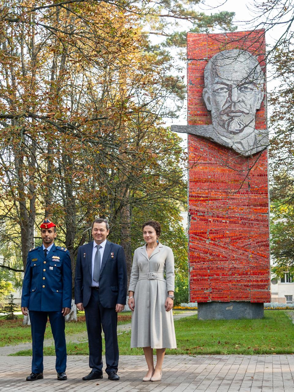 jsc2019e052747 - At the Gagarin Cosmonaut Training Center in Star City, Russia, the image of Vladimir Lenin serves as a backdrop as spaceflight participant Hazzaa Ali Almansoori of the United Arab Emirates (left) and Expedition 61 crewmembers Oleg Skripochka of Roscosmos (center) and Jessica Meir of NASA (right) pose for pictures Sept. 10 before traveling to a nearby airfield for a flight to their launch site at the Baikonur Cosmodrome in Kazakhstan. They will launch on Sept. 25 from the Baikonur Cosmodrome on the Soyuz MS-15 spacecraft for a mission on the International Space Station...NASA/Beth Weissinger