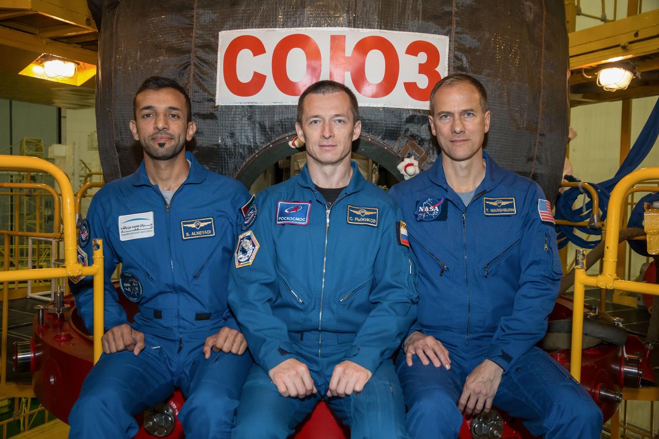 In the Integration Building at the Baikonur Cosmodrome in Kazakhstan, backup spaceflight participant Sultan Al-Neyadi of the United Arab Emirates (left) and backup Expedition 61 crewmates Sergey Ryzhikov of Roscosmos (center) and Tom Marshburn of NASA (right) pose for pictures Sept. 11 in front of the Soyuz MS-15 spacecraft. They are the backups to the prime crew, spaceflight participant Hazzaa Ali Almansoori of the United Arab Emirates and Expedition 61 crewmembers Oleg Skripochka of Roscosmos and Jessica Meir of NASA, who will launch Sept. 25 on the Soyuz MS-15 spacecraft from the Baikonur Cosmodrome for a mission on the International Space Station. NASA/Victor Zelentsov
