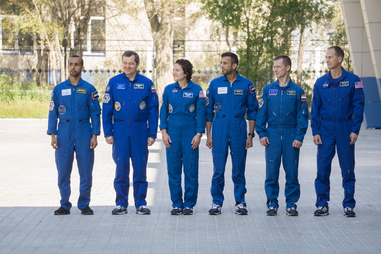 jsc2019e052900 - At their Cosmonaut Hotel crew quarters in Baikonur, Kazakhstan, the prime and backup crewmembers for the next launch to the International Space Station attend flag-raising ceremonies Sept. 12. From left to right are the prime crewmembers, Hazzaa Ali Almansoori of the United Arab Emirates and Expedition 61 crewmembers Oleg Skripochka of Roscosmos and Jessica Meir of NASA and their backups, Sultan Al-Neyadi of the United Arab Emirates, Sergey Ryzhikov of Roscosmos and Tom Marshburn of NASA. Almansoori, Skripochka and Meir will launch Sept. 25 on the Soyuz MS-15 spacecraft for a mission on the International Space Station...NASA/Victor Zelentsov.