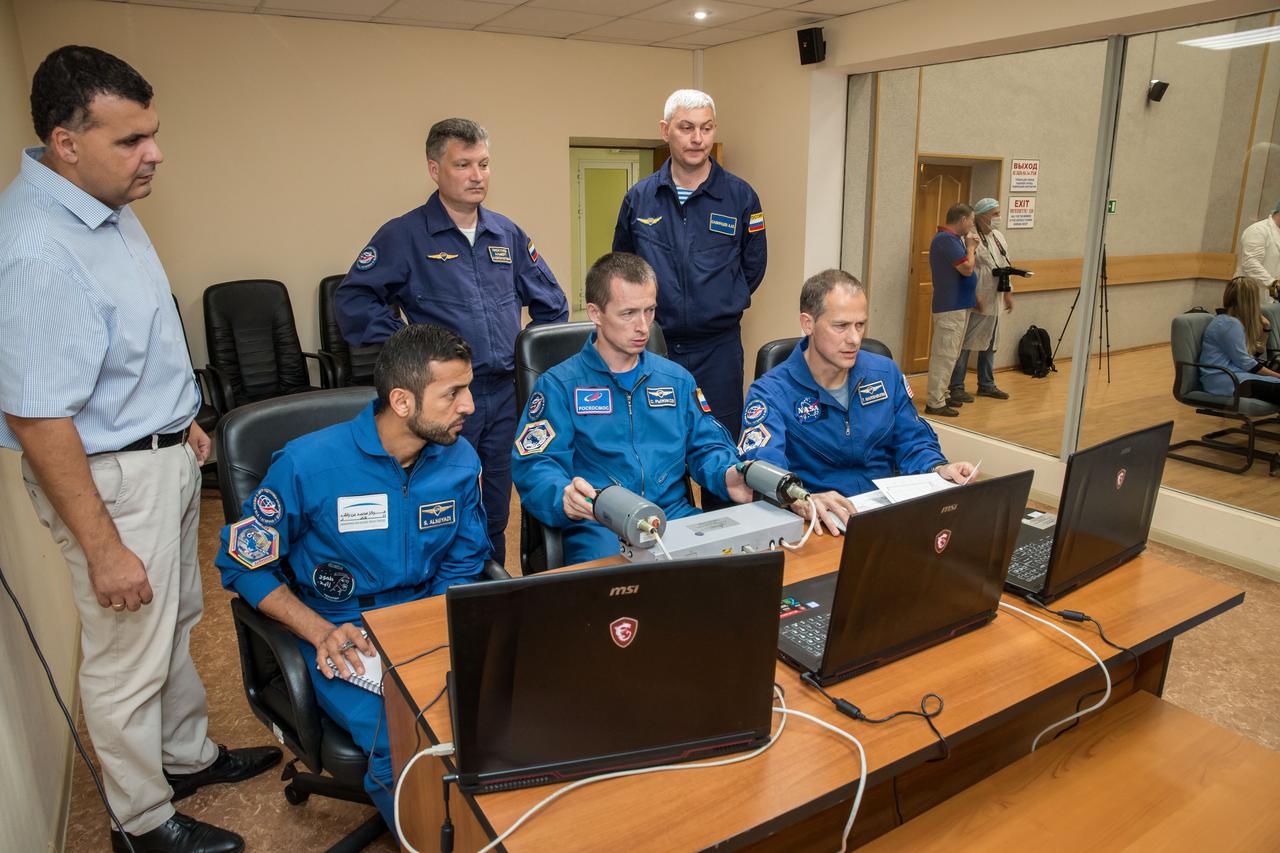 jsc2019e053718 - At the Cosmonaut Hotel crew quarters in Baikonur, Kazakhstan, the backups to the next crew to launch to the International Space Station practices rendezvous techniques Sept. 18 as part of pre-launch training. Backup spaceflight participant Sultan Al-Neyadi of the United Arab Emirates (left) and crewmates Sergey Ryzhikov of Roscosmos (center) and Tom Marshburn of NASA (right) will back up the prime crew, spaceflight participant Hazzaa ali Almansoori of the United Arab Emirates, Oleg Skripochka of Roscosmos and Jessica Meir of NASA, who are set to launch Sept. 25 from the Baikonur Cosmodrome in Kazakhstan on the Soyuz MS-15 spacecraft for a mission on the International Space Station...NASA/Victor Zelentsov
