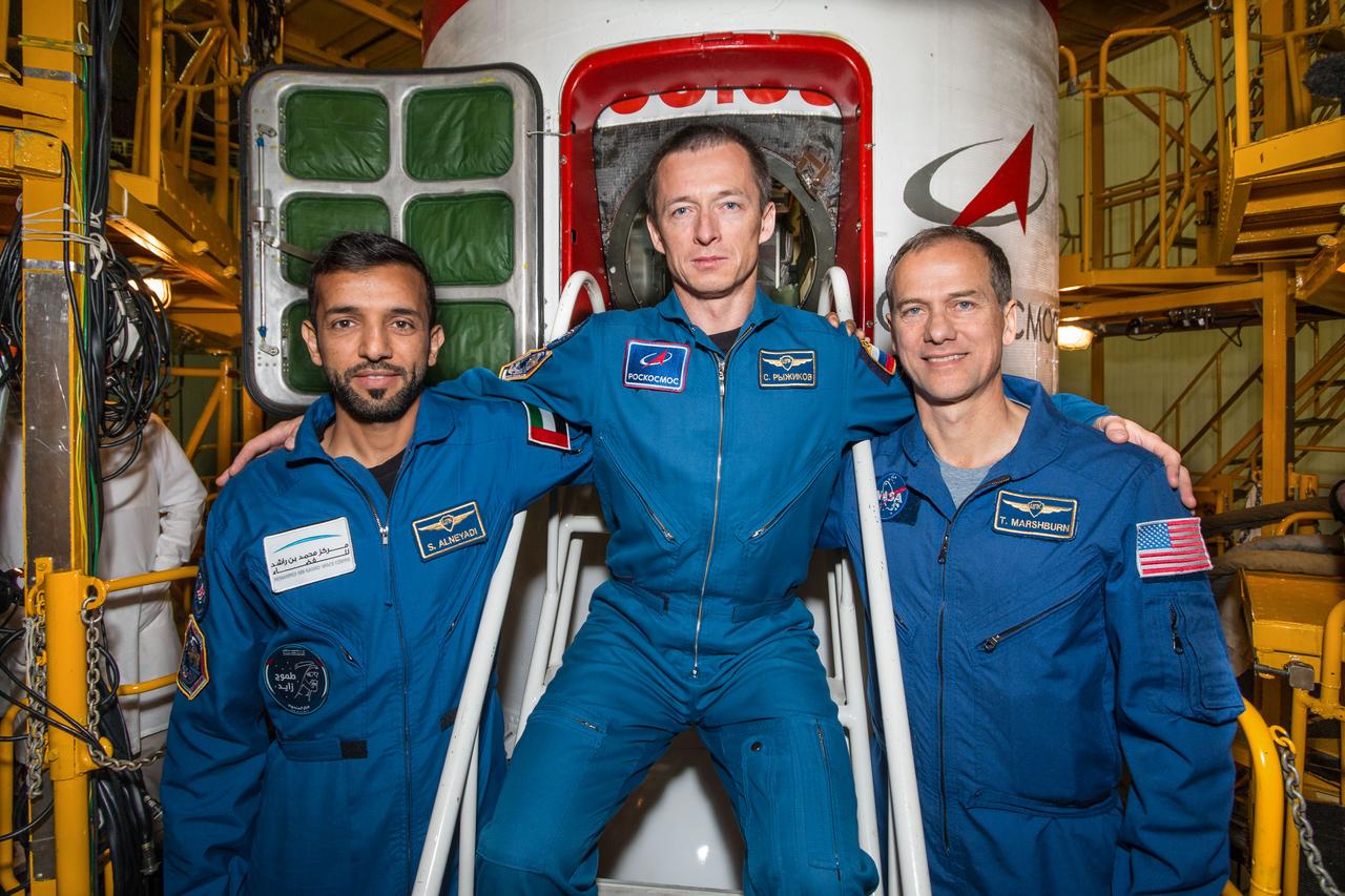 jsc2019e053734 - At the Baikonur Cosmodrome in Kazakhstan, the backups to the next crew to launch to the International Space Station pose for pictures Sept. 20 in front of the Soyuz MS-15 spacecraft. From left to right are backup spaceflight participant Sultan Al-Neyadi of the United Arab Emirates and backup Expedition 61 crewmembers Sergey Ryzhikov of Roscosmos and Tom Marshburn of NASA. They are the backups to the prime crew, Hazzaa Ali Almansoori of the United Arab Emirates, Oleg Skripochka of Roscosmos and Jessica Meir of NASA, who will launch Sept. 25 on the Soyuz MS-15 spacecraft for a mission on the International Space Station...NASA/Victor Zelentsov