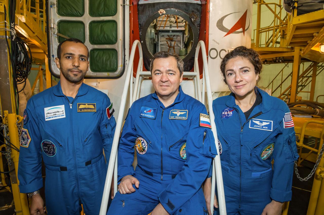 jsc2019e053736 - At the Baikonur Cosmodrome in Kazakhstan, spaceflight participant Hazzaa Ali Almansoori of the United Arab Emirates (left), Oleg Skripochka of Roscosmos (center) and Jessica Meir of NASA (right) pose for pictures in front of the Soyuz MS-15 spacecraft Sept. 20 during final fit check activities. They will launch Sept. 25 on the Soyuz MS-15 spacecraft for a mission on the International Space Station...NASA/Victor Zelentsov