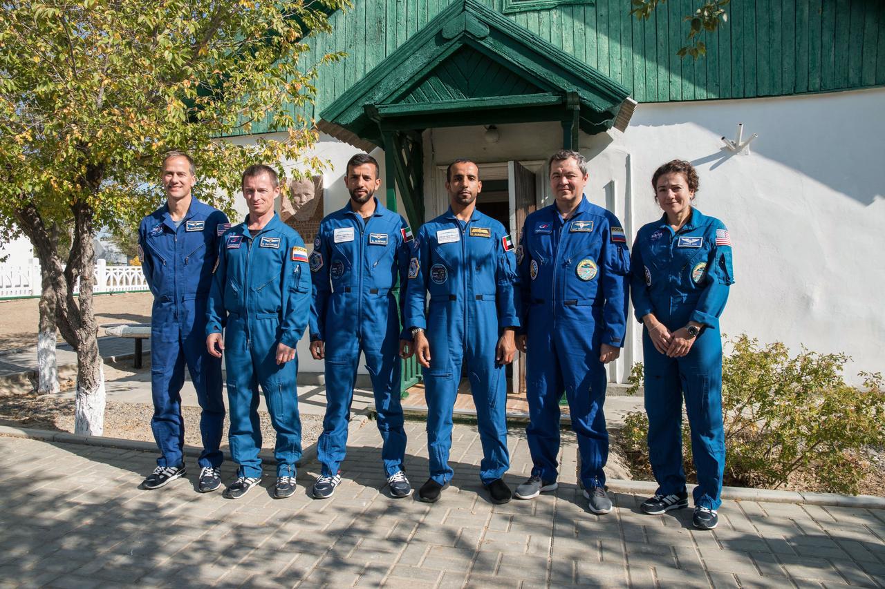 jsc2019e053744 - At the Baikonur Cosmodrome in Kazakhstan, the prime and backup crewmembers for the next launch to the International Space Station pose for pictures Sept. 20 in front of the cottage in which Yuri Gagarin slept on the eve of his launch April 12, 1961 to become the first human to fly in space. From left to right are Expedition 61 backup crewmembers Tom Marshburn of NASA and Sergey Ryzhikov of Roscosmos and backup spaceflight participant Sultan Al-Neyadi of the United Arab Emirates and the prime crew, spaceflight participant Hazzaa Ali Almansoori of the United Arab Emirates and Expedition 61 crewmembers Oleg Skripochka of Roscosmos and Jessica Meir of NASA, who will launch Sept. 25 on the Soyuz MS-15 spacecraft for a mission on the International Space Station...NASA/Victor Zelentsov