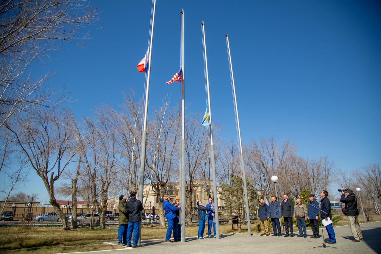 jsc2020e016864 - At the Cosmonaut Hotel crew quarters in Baikonur, Kazakhstan, the Expedition 63 prime and backup crewmembers raise the Russian, U.S. and Kazakh flags March 26 in a traditional ceremony. From left to right are prime crewmembers Ivan Vagner and Anatoly Ivanishin of Roscosmos, prime crewmember Chris Cassidy of NASA and his backup, Steve Bowen of NASA and backup crewmembers Sergey Ryzhikov and Andrei Babkin. Cassidy, Ivanishin and Vagner will launch April 9 from the Baikonur Cosmodrome on the Soyuz MS-16 spacecraft for a six-and-a-half month mission on the International Space Station...Courtesy/Roscosmos.