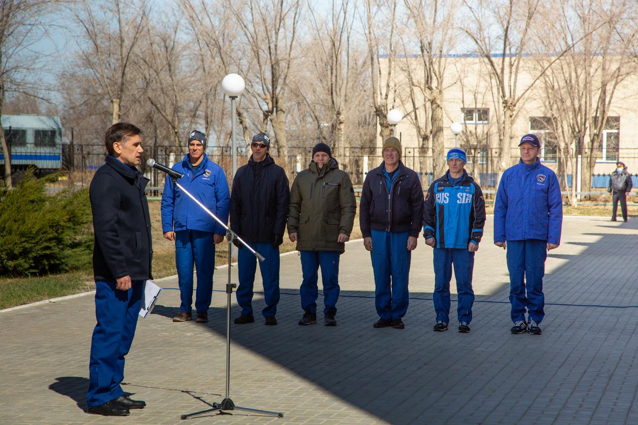 jsc2020e016866 - At the Cosmonaut Hotel crew quarters in Baikonur, Kazakhstan, cosmonaut Yuri Malenchenko (left), who is the Deputy Director of the Gagarin Cosmonaut Training Center, presides over the traditional flag-raising ceremony March 26 as part of pre-launch activities for the Expedition 63 crew. The prime and backup crews are seen from left to right --- prime crewmembers Chris Cassidy of NASA, Anatoly Ivanishin and Ivan Vagner of Roscosmos and the backup crewmembers, Steve Bowen of NASA and Sergey Ryzhikov and Andrei Babkin of Roscosmos. Cassidy, Ivanishin and Vagner will launch April 9 from the Baikonur Cosmodrome on the Soyuz MS-16 spacecraft for a six-and-a-half month mission on the International Space Station...Courtesy/Roscosmos.
