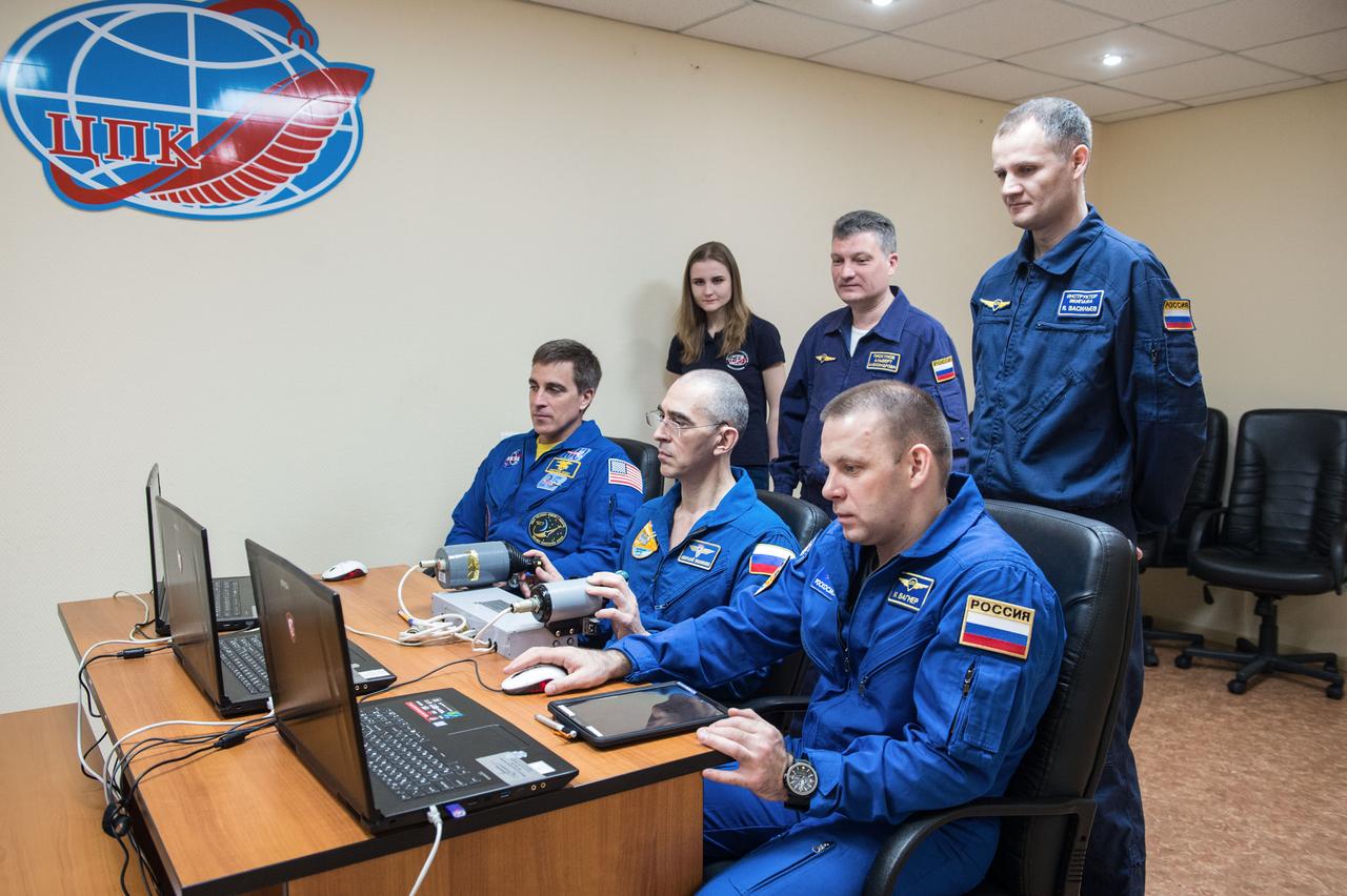 jsc2020e016953 - At the Cosmonaut Hotel crew quarters in Baikonur, Kazakhstan, Expedition 63 crewmembers Chris Cassidy of NASA (left) and Anatoly Ivanishin (center) and Ivan Vagner (right) of Roscosmos practice rendezvous techniques on a laptop simulator April 1 as they prepare for launch. They will launch April 9 on the Soyuz MS-16 spacecraft from the Baikonur Cosmodrome in Kazakhstan for a six-and-a-half month mission on the International Space Station...Andrey Shelepin/Gagarin Cosmonaut Training Center.