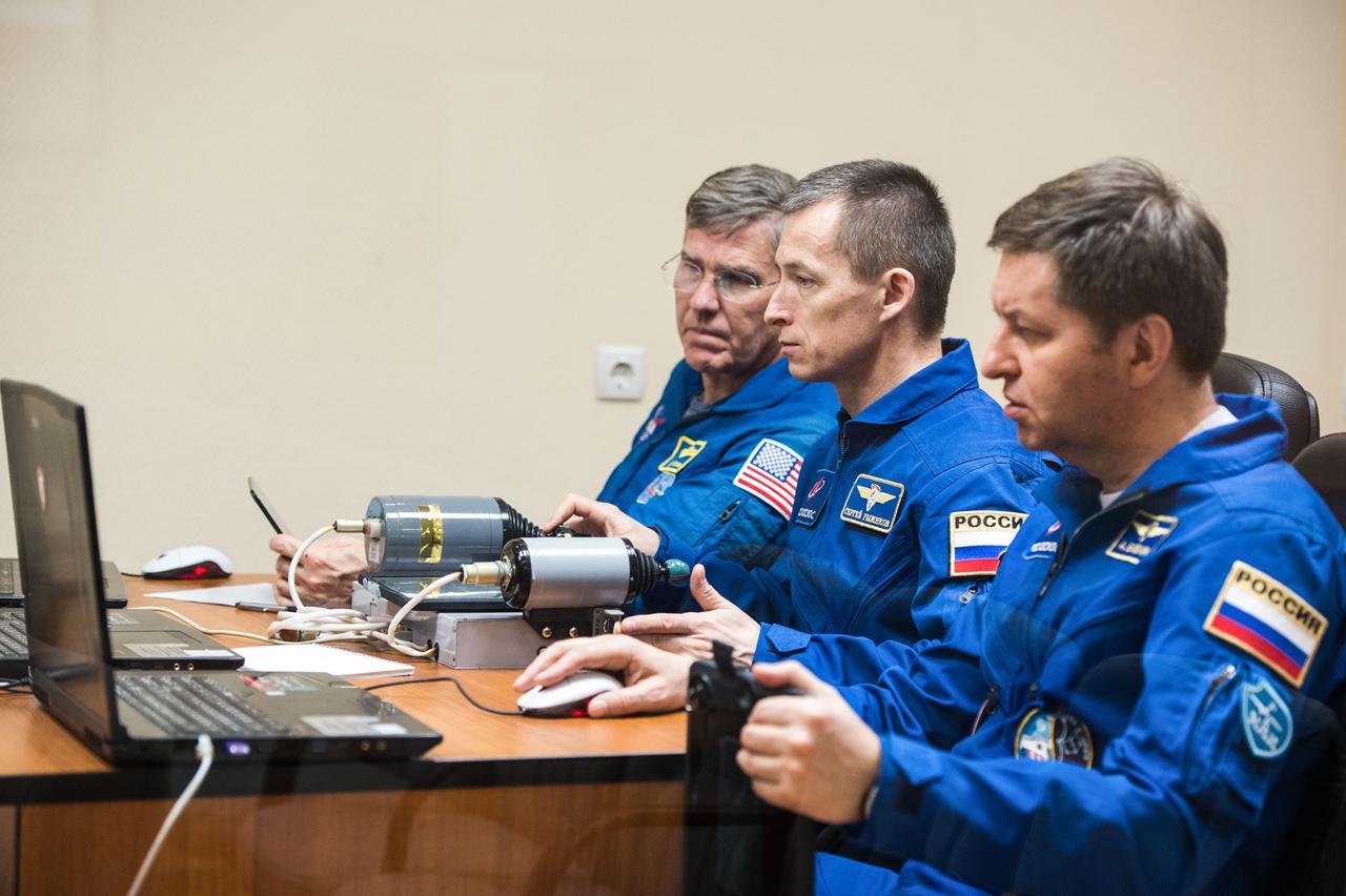 jsc2020e016955 - At the Cosmonaut Hotel crew quarters in Baikonur, Kazakhstan, Expedition 63 backup crewmembers Steve Bowen of NASA (left) and Sergey Ryzhikov (center) and Andrei Babkin (right) of Roscosmos practice rendezvous techniques on a laptop simulator April 1. They are the backups to the prime crew, Chris Cassidy of NASA and Anatoly Ivanishin and Ivan Vagner of Roscosmos, who will launch April 9 on the Soyuz MS-16 spacecraft from the Baikonur Cosmodrome in Kazakhstan for a six-and-a-half month mission on the International Space Station...Andrey Shelepin/Gagarin Cosmonaut Training Center..