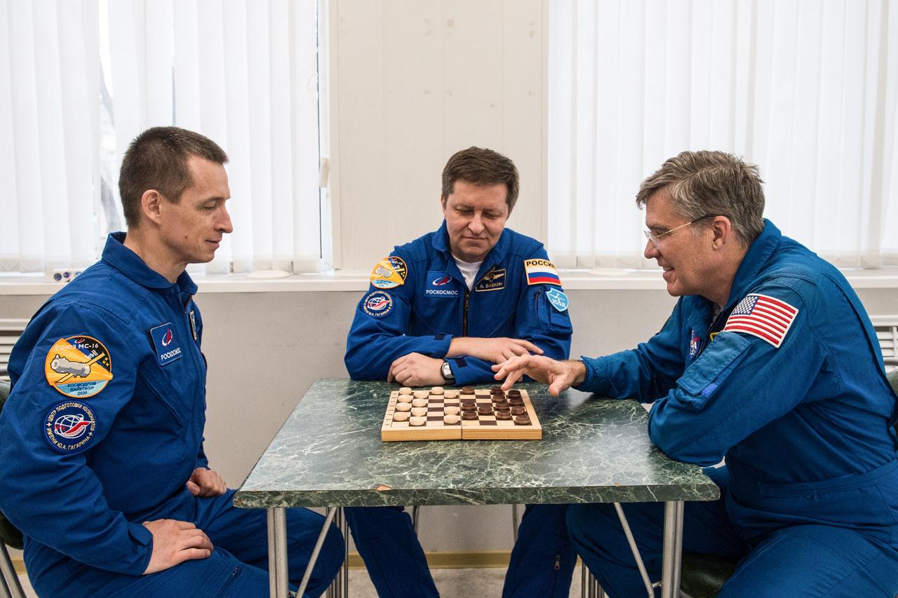 jsc2020e016958 - At the Cosmonaut Hotel crew quarters in Baikonur, Kazakhstan, Expedition 63 backup crewmembers Sergey Ryzhikov (left) and Andrei Babkin (center) of Roscosmos and Steve Bowen of NASA (right) share a game of chess April 1. They are the backups to the prime crew, Chris Cassidy of NASA and Anatoly Ivanishin and Ivan Vagner of Roscosmos, who will launch April 9 on the Soyuz MS-16 spacecraft from the Baikonur Cosmodrome in Kazakhstan for a six-and-a-half month mission on the International Space Station...Andrey Shelepin/Gagarin Cosmonaut Training Center.