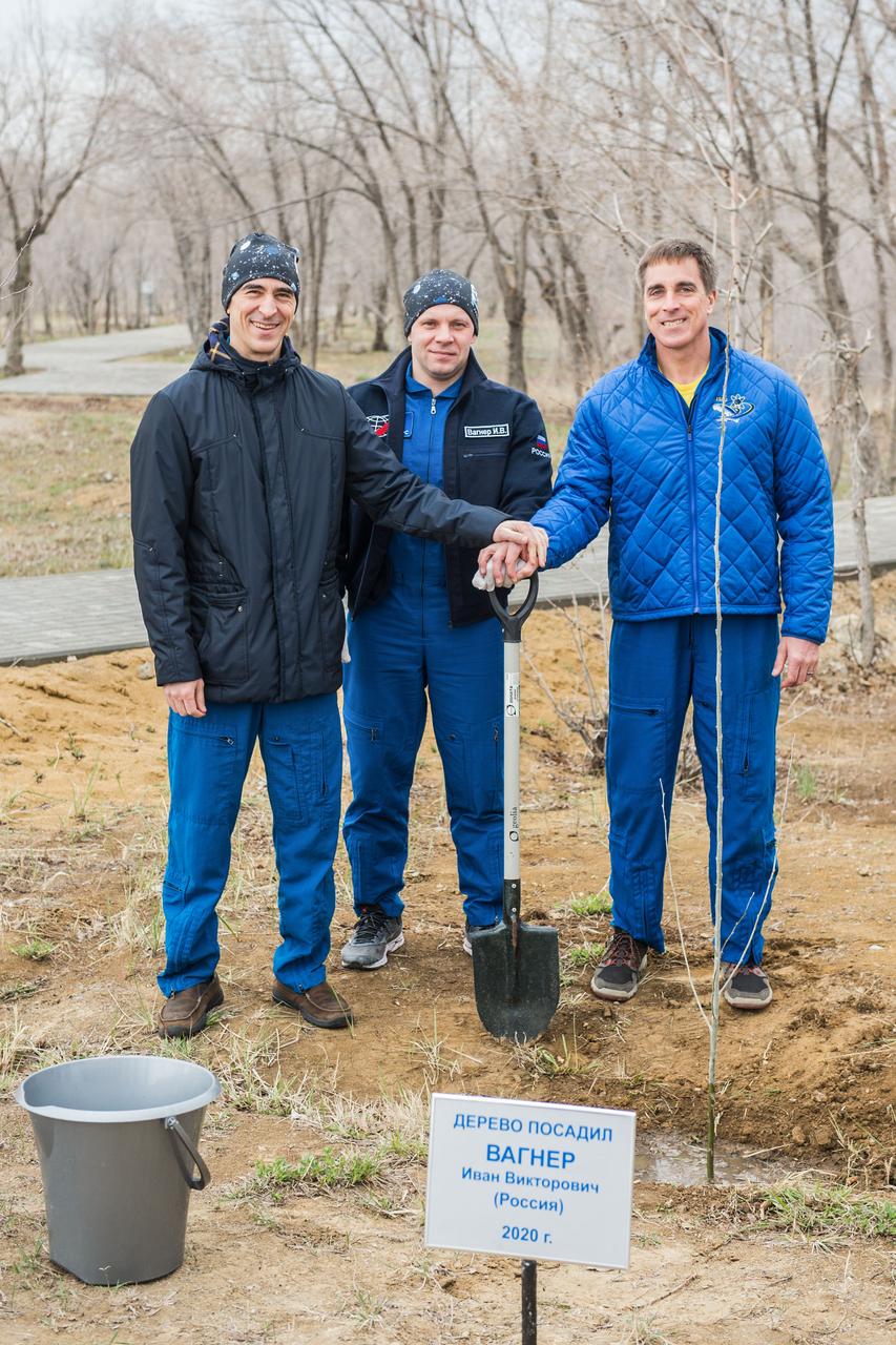 jsc2020e016972 - At the Cosmonaut Hotel crew quarters in Baikonur, Kazakhstan, Expedition 63 crewmembers Anatoly Ivanishin (left) and Ivan Vagner (center) of Roscosmos and Chris Cassidy of NASA (right) pose for pictures April 1 after Vagner planted a tree bearing his name in pre-launch activities. They will launch April 9 on the Soyuz MS-16 spacecraft from the Baikonur Cosmodrome in Kazakhstan for a six-and-a-half month mission on the International Space Station...Andrey Shelepin/Gagarin Cosmonaut Training Center.