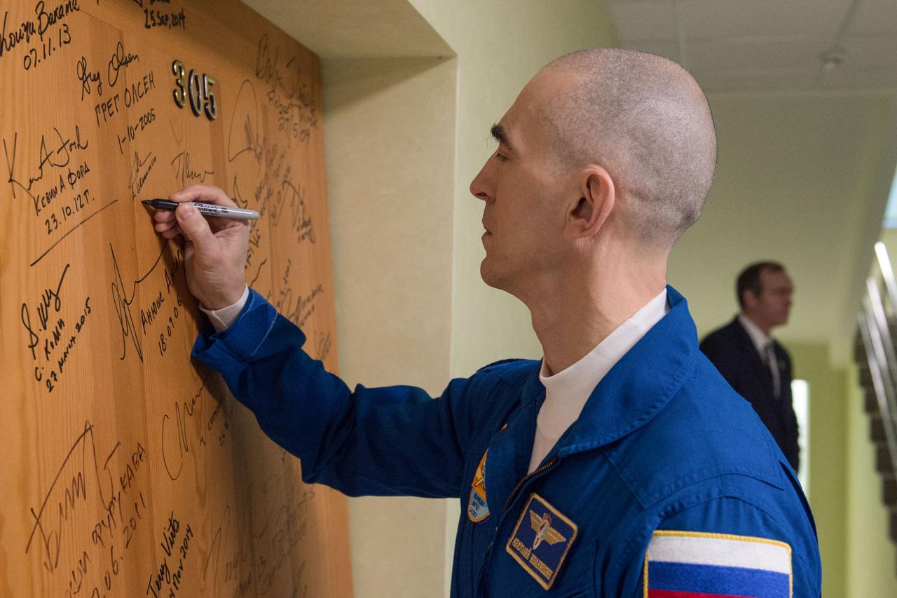 jsc2020e017062 - Expedition 63 Preflight - Expedition 63 crewmember Anatoly Ivanishin of Roscosmos signs a door in the Cosmonaut Hotel prior to departing for launch on a Soyuz rocket with Chris Cassidy of NASA, and Ivan Vagner of Roscosmos, Thursday, April 9, 2020 in Baikonur, Kazakhstan. The crew is beginning a six-and-a-half month mission on the International Space Station.  Photo Credit: (NASA/GCTC/Andrey Shelepin)