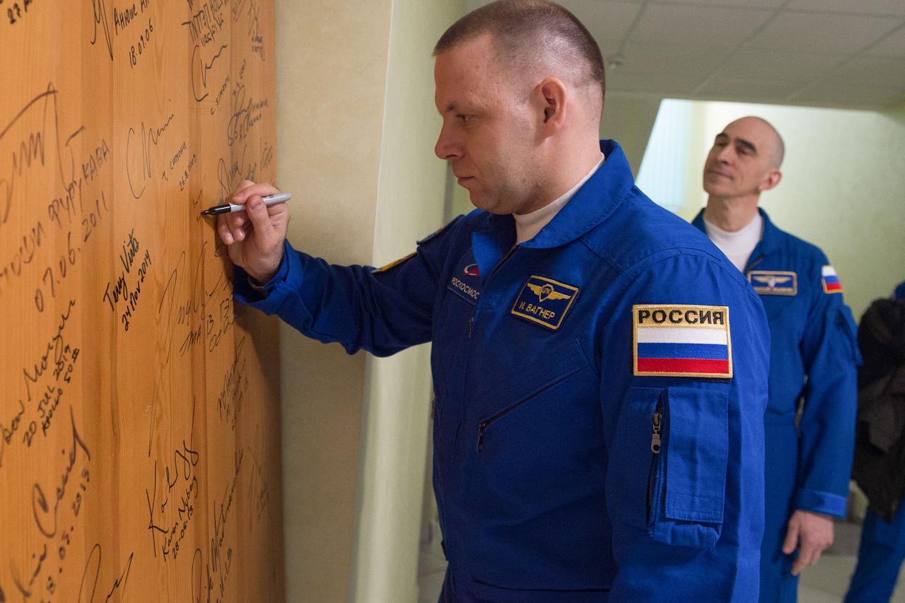 jsc2020e017063 - Expedition 63 Preflight - Expedition 63 crewmember Ivan Vagner of Roscosmos signs a door in the Cosmonaut Hotel prior to departing for launch on a Soyuz rocket with Chris Cassidy of NASA, and Anatoly Ivanishin of Roscosmos, Thursday, April 9, 2020 in Baikonur, Kazakhstan. The crew is beginning a six-and-a-half month mission on the International Space Station.  Photo Credit: (NASA/GCTC/Andrey Shelepin)