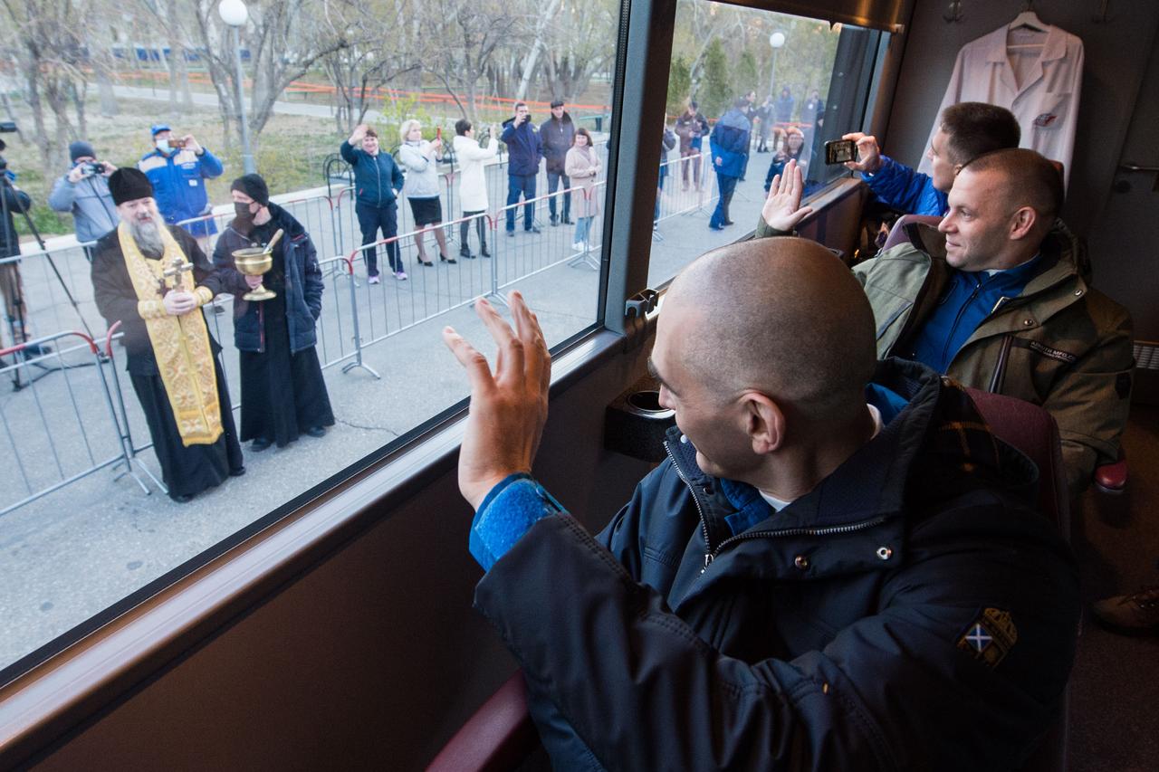 jsc2020e017067 - Expedition 63 Preflight - Expedition 63 crewmembers Anatoly Ivanishin, left, Ivan Vagner of Roscosmos, center, and Chris Cassidy of NASA, right, wave farewell as they depart their Cosmonaut Hotel crew quarters in Baikonur, Kazakhstan to travel to their suit up facility for launch on the Soyuz MS-16 rocket from the Baikonur Cosmodrome, Thursday, April 9, 2020. They are beginning a six-and-a-half month mission on the International Space Station. Photo Credit: (NASA/GCTC/Andrey Shelepin)