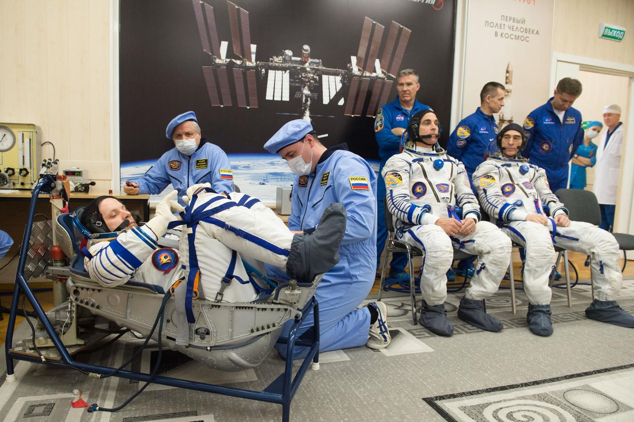 jsc2020e017089 - Expedition 63 Preflight - Expedition 63 crewmember Ivan Vagner of Roscosmos, left, has his Sokol suit pressure checked ahead of his launch on a Soyuz rocket with Chris Cassidy of NASA, seated center, and Anatoly Ivanishin of Roscosmos, seated right, Thursday, April 9, 2020 at the Baikonur Cosmodrome in Kazakhstan. A few hours later, they lifted off for a six-and-a-half month mission on the International Space Station. Photo Credit: (NASA/GCTC/Andrey Shelepin)