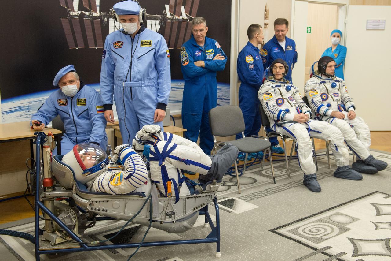 jsc2020e017096 - Expedition 63 Preflight - Expedition 63 crewmember Chris Cassidy of NASA, left, has his Sokol suit pressure checked ahead of his launch on a Soyuz rocket with Anatoly Ivanishin of Roscosmos, seated center, and Ivan Vagner of Roscosmos, seated right, Thursday, April 9, 2020 at the Baikonur Cosmodrome in Kazakhstan. A few hours later, they lifted off for a six-and-a-half month mission on the International Space Station. Photo Credit: (NASA/GCTC/Andrey Shelepin)...