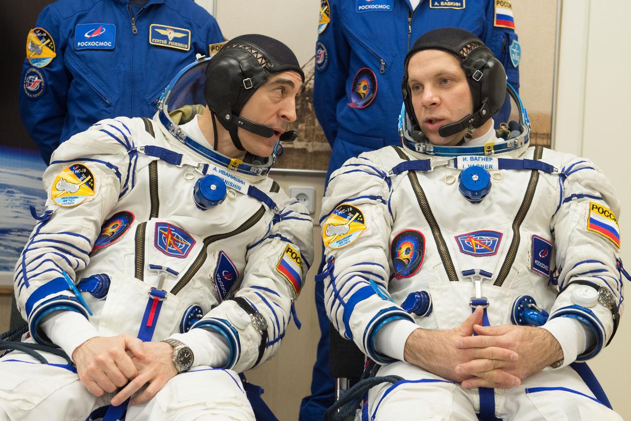jsc2020e017099 - Expedition 63 Preflight - Expedition 63 crewmembers Anatoly Ivanishin, left, and Ivan Vagner of Roscosmos, talk as Chris Cassidy of NASA has his Sokol suit pressure checked ahead of their launch on a Soyuz rocket, Thursday, April 9, 2020 at the Baikonur Cosmodrome in Kazakhstan. A few hours later, they lifted off for a six-and-a-half month mission on the International Space Station. Photo Credit: (NASA/GCTC/Andrey Shelepin)...