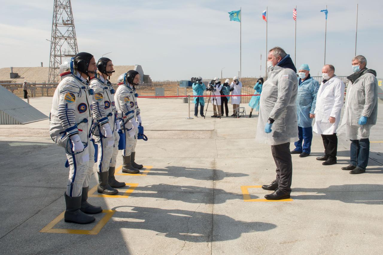 jsc2020e017115 - Expedition 63 Preflight - Expedition 63 crewmembers Chris Cassidy of NASA, left, Anatoly Ivanishin and Ivan Vagner of Roscosmos, report to Roscosmos Director General Dmitry Rogozin, right, as they arrive at the launch pad, Thursday, April 9, 2020 at the Baikonur Cosmodrome in Kazakhstan. A few hours later, they lifted off on a Soyuz rocket for a six-and-a-half month mission on the International Space Station. Photo Credit: (NASA/GCTC/Andrey Shelepin)...