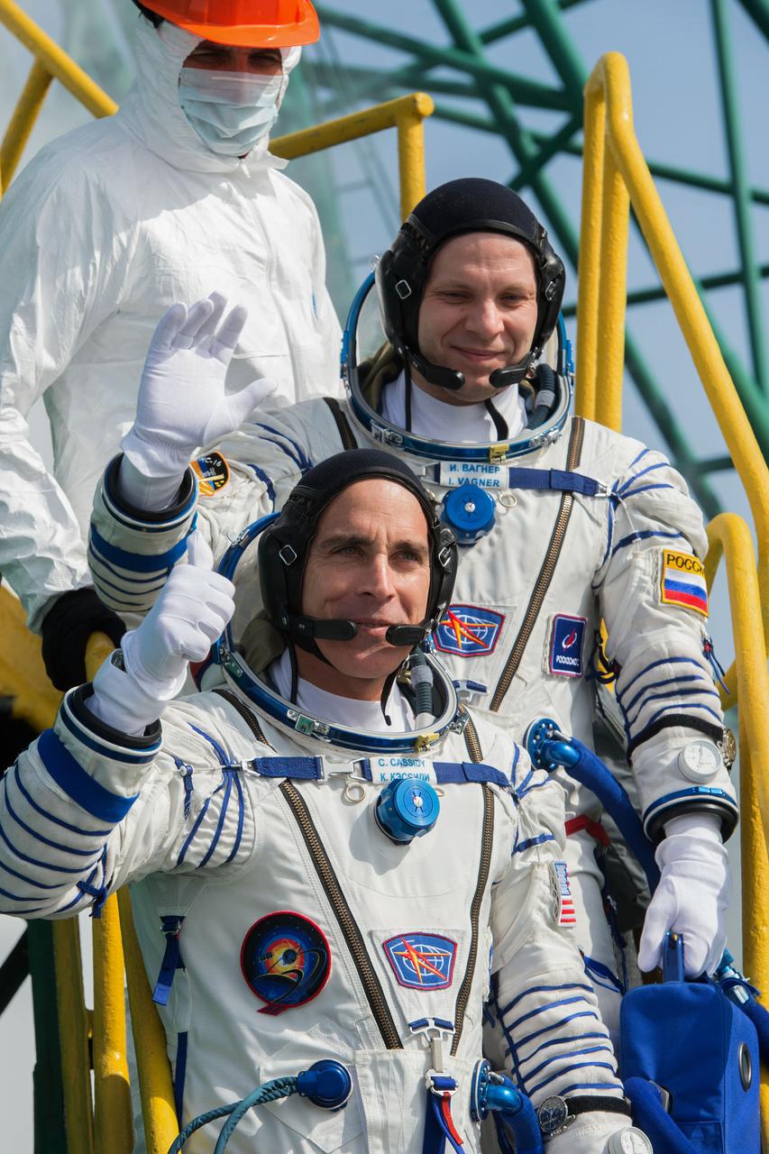 jsc2020e017121 - Expedition 63 Crew Waves Farewell - Expedition 63 crewmembers Ivan Vagner of Roscosmos, top, and Chris Cassidy of NASA wave goodbye as they and Anatoly Ivanishin of Roscosmos prepare to climb aboard the Soyuz MS-16 rocket at Site 31 at the Baikonur Cosmodrome in Kazakhstan, Thursday, April 9, 2020. They launched a short time later to the International Space Station for the start of a six-and-a-half month mission. Photo Credit: (NASA/GCTC/Andrey Shelepin)